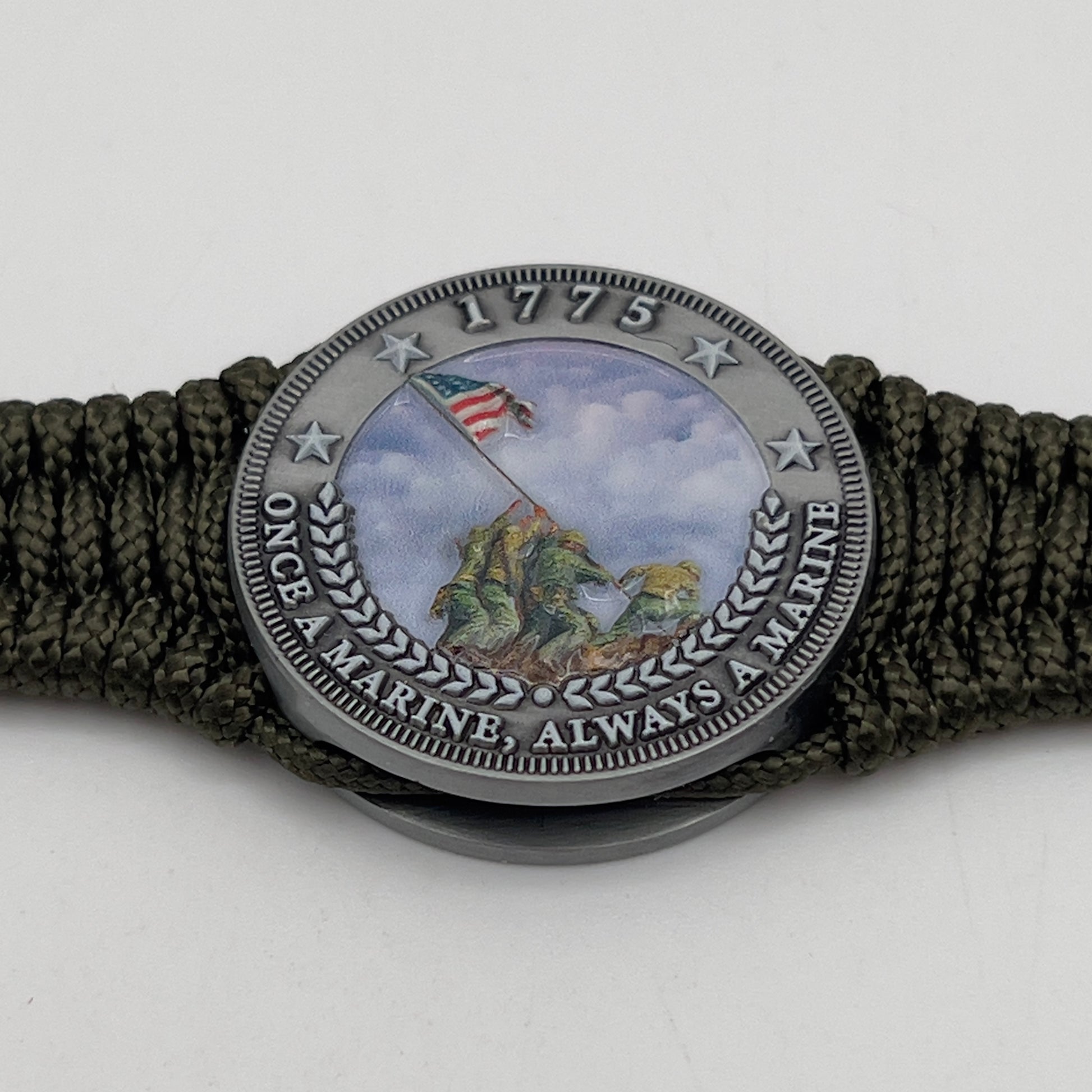 Thin, narrow, flexible and comfortable braided United States Marine Corps Iwo Jima bracelet featuring an antique silver plated UV painted Iwo Jima flag raising medallion, a silver Cobra style tactical buckle and woven with Olive Drab type-1 paracord.