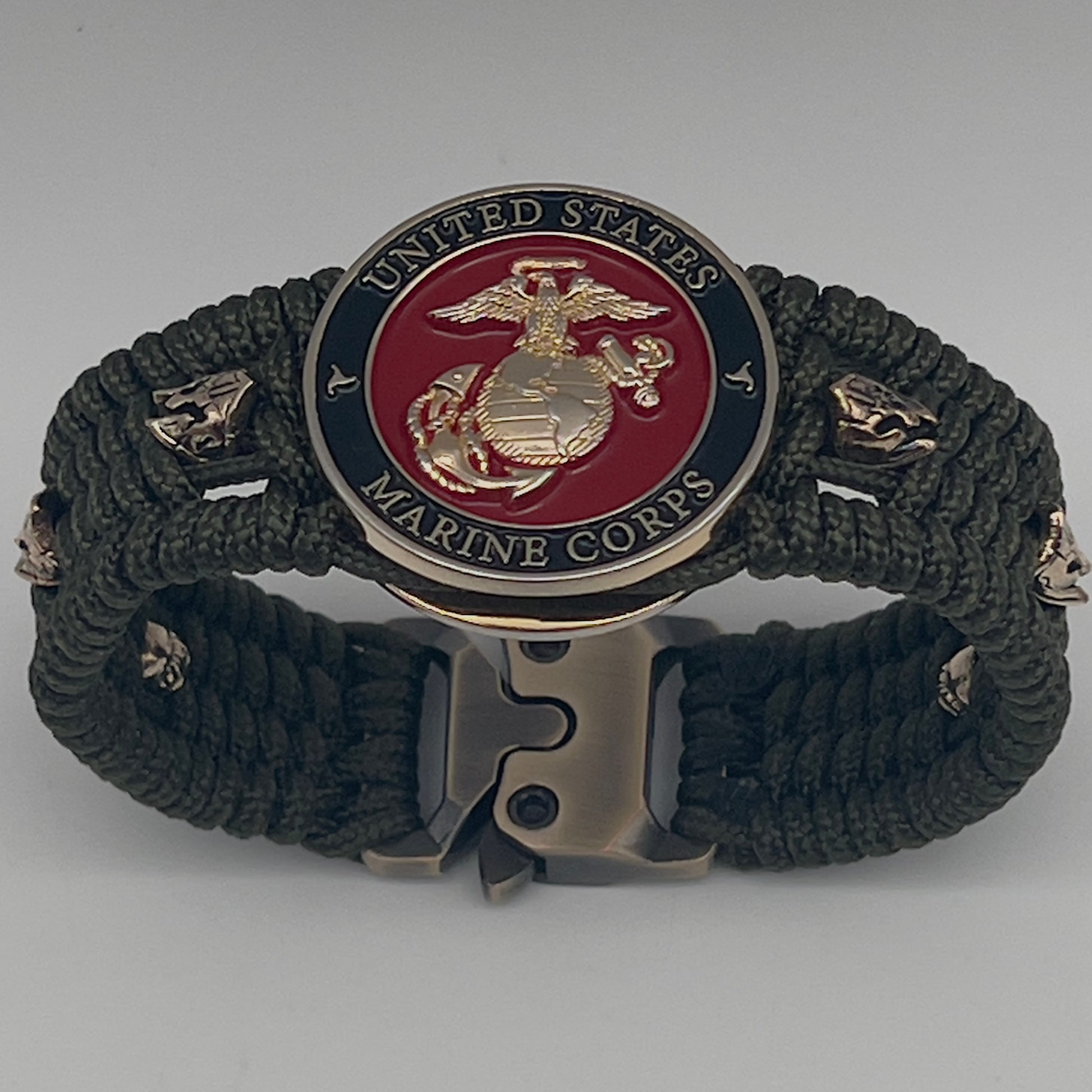 Thin, medium width, flexible and comfortable braided United States Marine Corps bracelet featuring a 24K gold plated USMC officer Eagle Globe and Anchor medallion, six Spartan micro beads, a gold Cobra style tactical buckle and woven with Olive Drab Type-1 paracord.