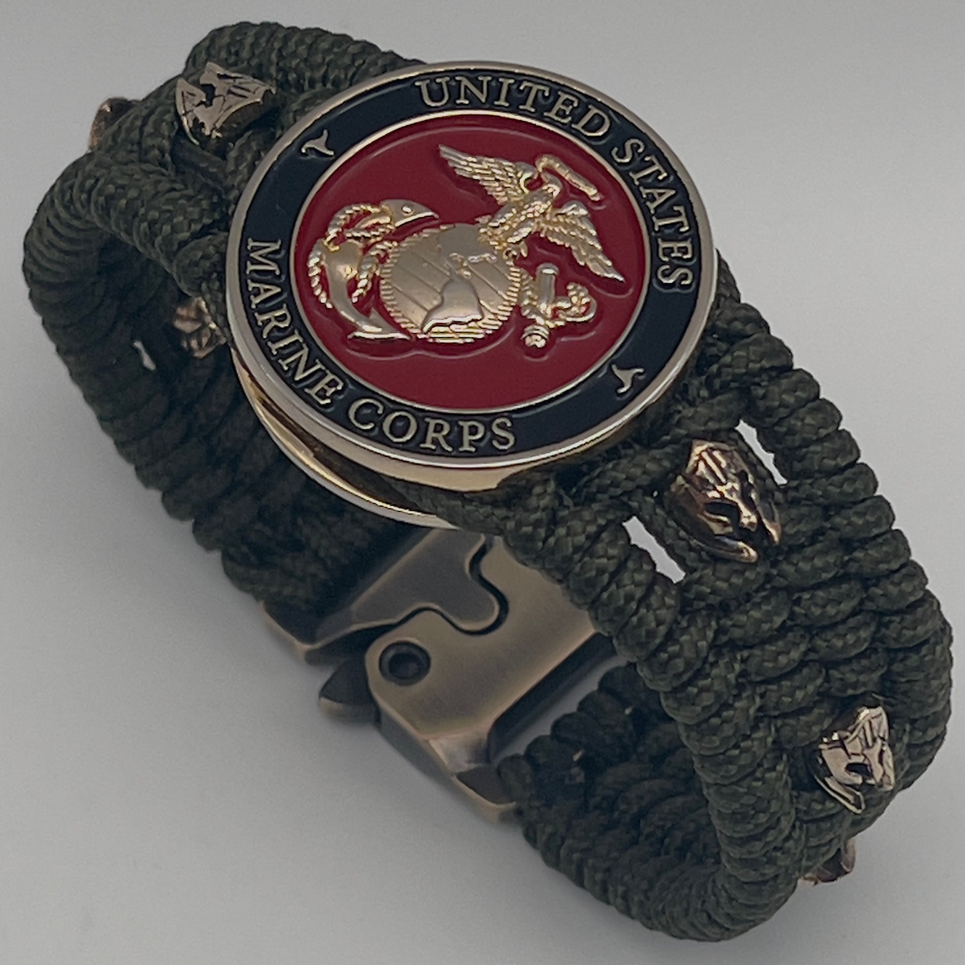 Thin, medium width, flexible and comfortable braided United States Marine Corps bracelet featuring a 24K gold plated USMC officer Eagle Globe and Anchor medallion, six Spartan micro beads, a gold Cobra style tactical buckle and woven with Olive Drab Type-1 paracord.