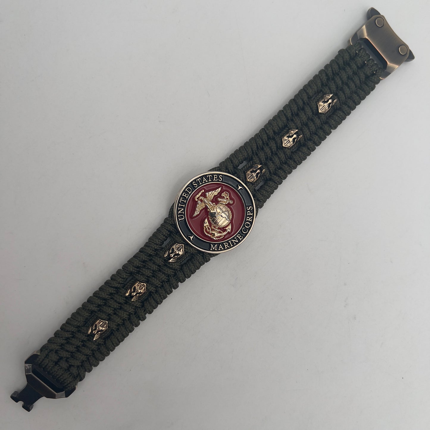 Thin, medium width, flexible and comfortable braided United States Marine Corps bracelet featuring a 24K gold plated USMC officer Eagle Globe and Anchor medallion, six Spartan micro beads, a gold Cobra style tactical buckle and woven with Olive Drab Type-1 paracord.
