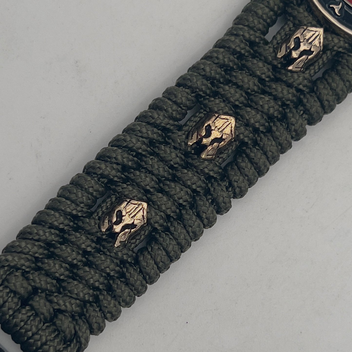 Thin, medium width, flexible and comfortable braided United States Marine Corps bracelet featuring a 24K gold plated USMC officer Eagle Globe and Anchor medallion, six Spartan micro beads, a gold Cobra style tactical buckle and woven with Olive Drab Type-1 paracord.