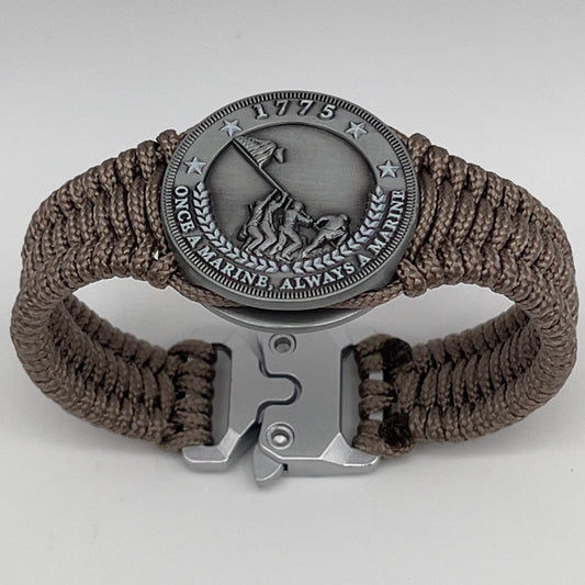Thin, narrow, flexible and comfortable braided United States Marine Corps Iwo Jima bracelet featuring an antique silver plated Iwo Jima flag raising medallion, a silver Cobra style tactical buckle and woven with tan type-1 paracord.