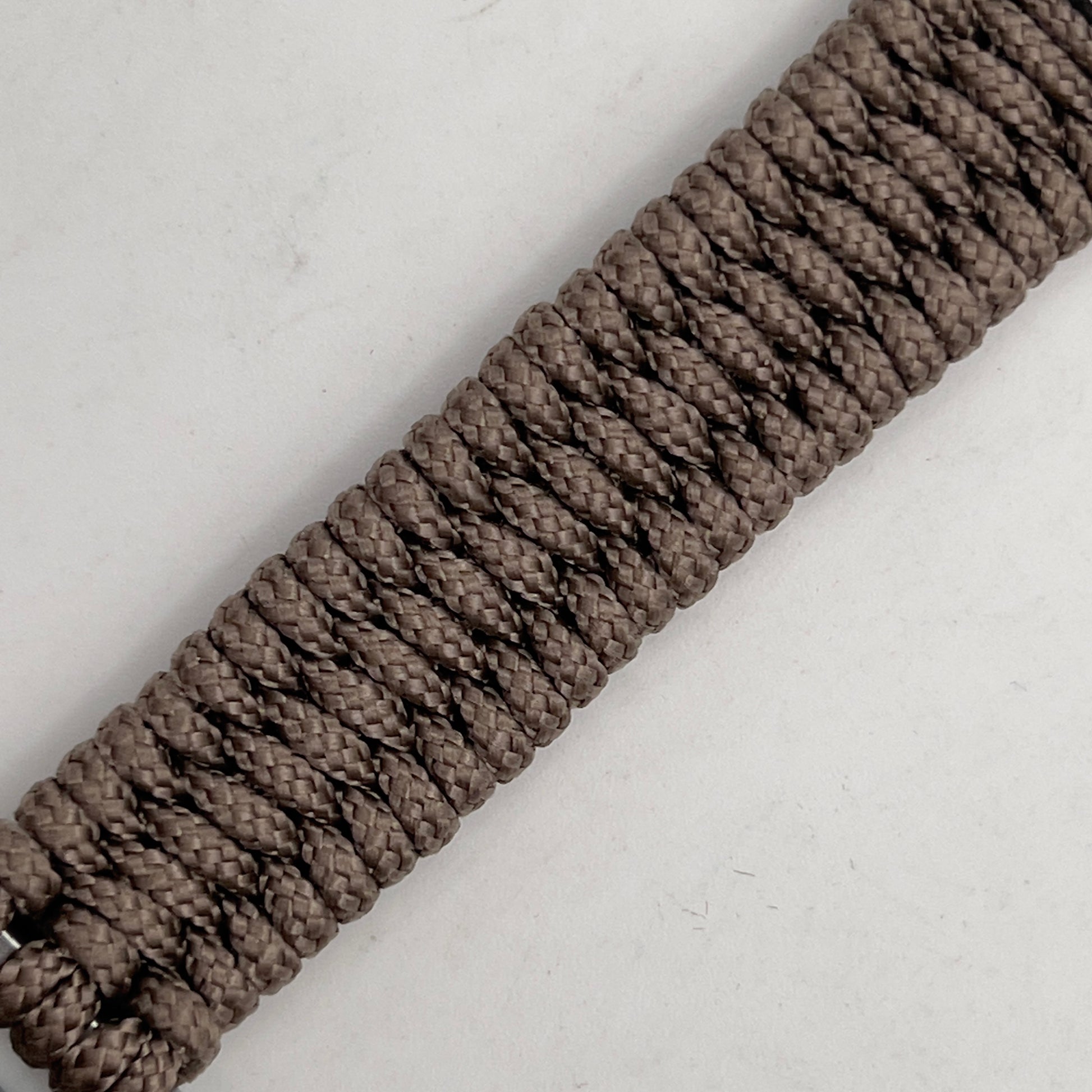 Thin, narrow, flexible and comfortable braided United States Marine Corps Iwo Jima bracelet featuring an antique silver plated Iwo Jima flag raising medallion, a silver Cobra style tactical buckle and woven with tan type-1 paracord.