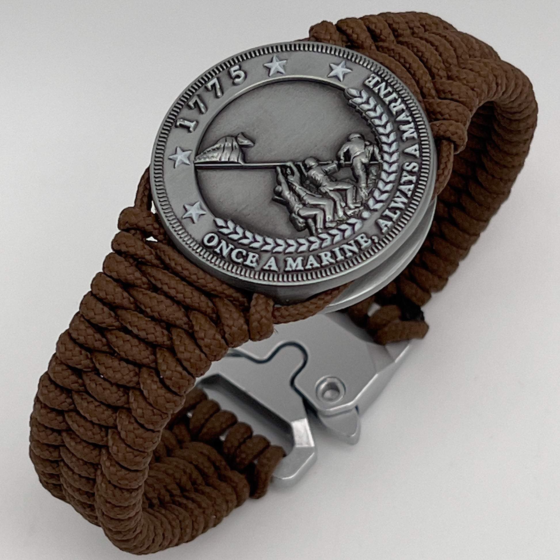 Thin, narrow, flexible and comfortable braided United States Marine Corps Iwo Jima bracelet featuring an antique silver plated Iwo Jima flag raising medallion, a silver Cobra style tactical buckle and woven with Coyote Brown type-1 paracord.