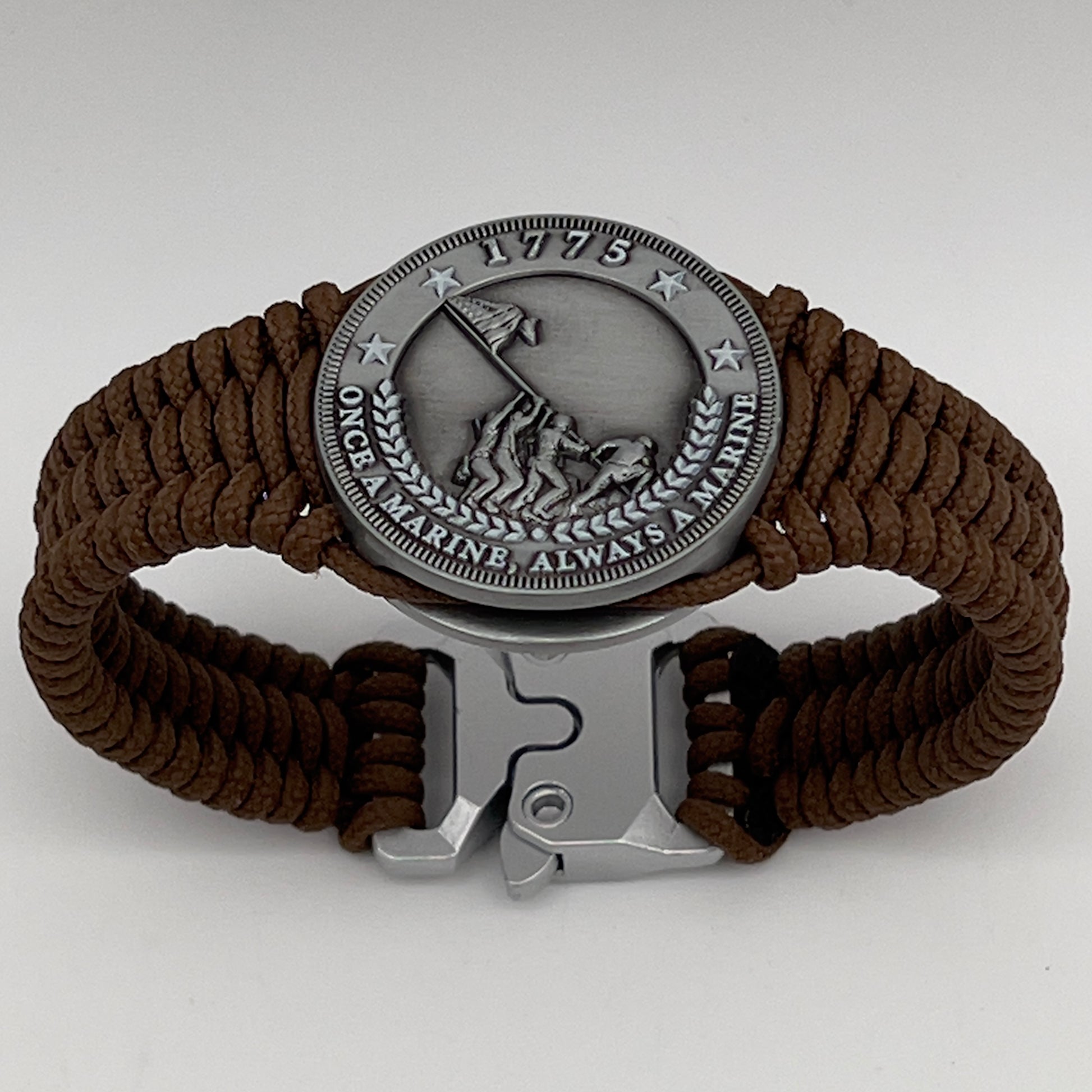 Thin, narrow, flexible and comfortable braided United States Marine Corps Iwo Jima bracelet featuring an antique silver plated Iwo Jima flag raising medallion, a silver Cobra style tactical buckle and woven with Coyote Brown type-1 paracord.
