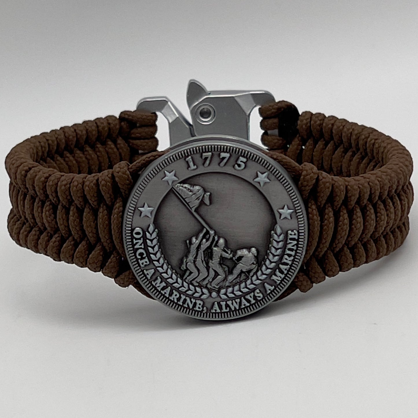 Thin, narrow, flexible and comfortable braided United States Marine Corps Iwo Jima bracelet featuring an antique silver plated Iwo Jima flag raising medallion, a silver Cobra style tactical buckle and woven with Coyote Brown type-1 paracord.