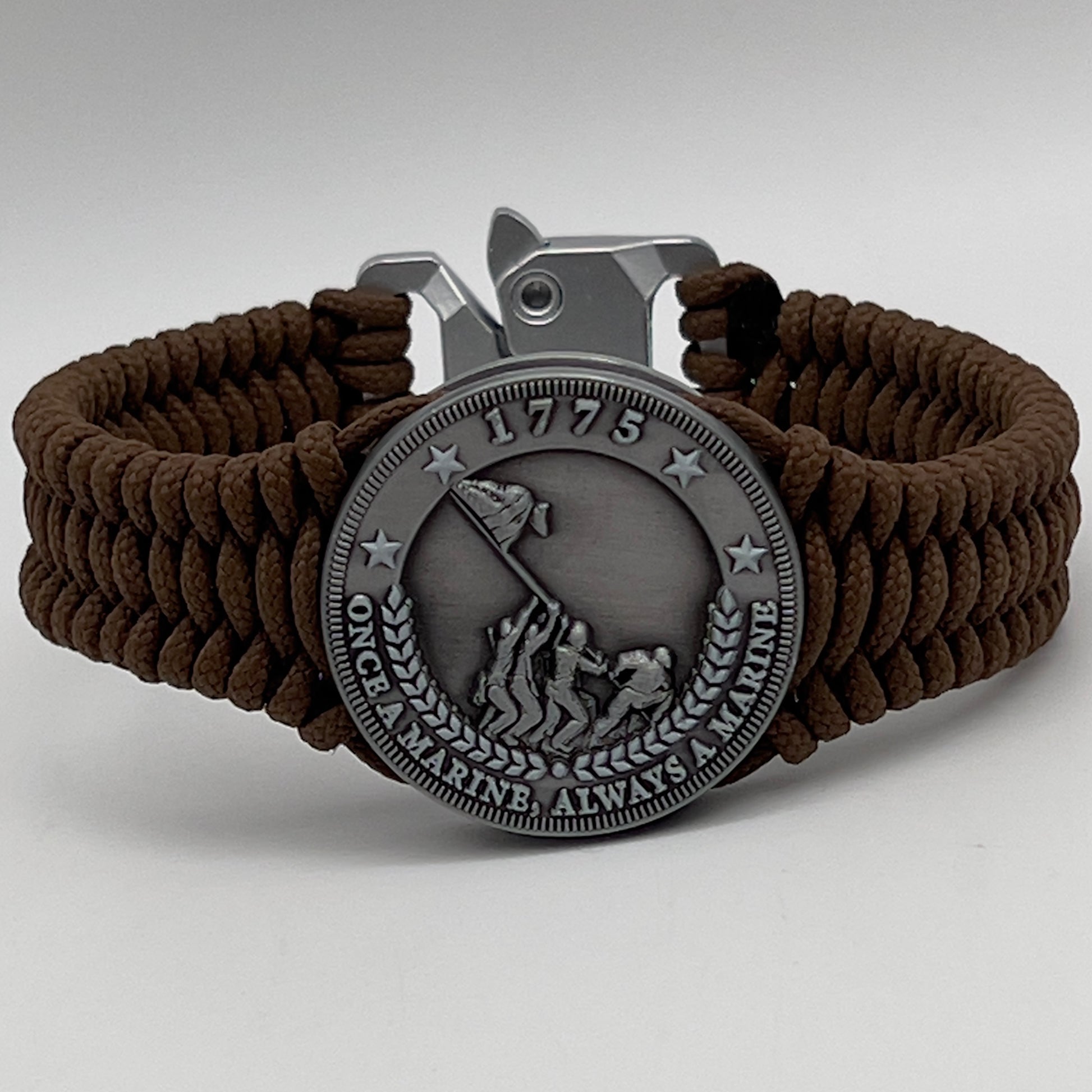 Thin, narrow, flexible and comfortable braided United States Marine Corps Iwo Jima bracelet featuring an antique silver plated Iwo Jima flag raising medallion, a silver Cobra style tactical buckle and woven with Coyote Brown type-1 paracord.