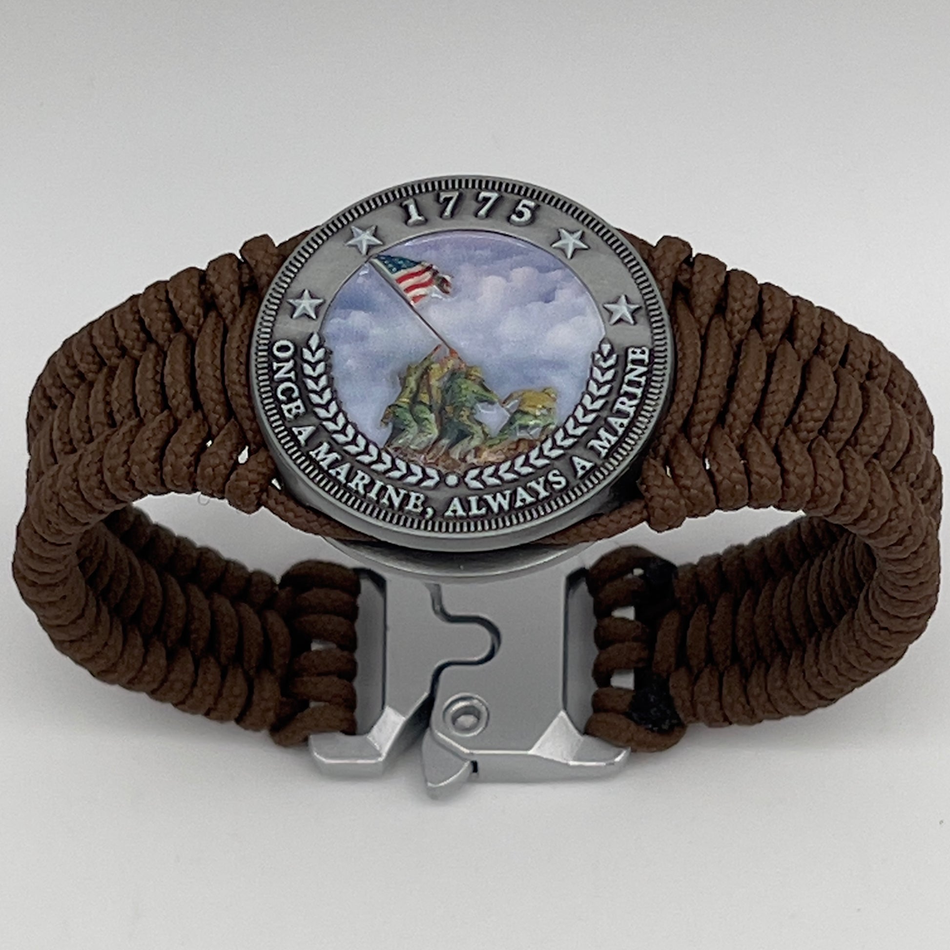 Thin, narrow, flexible and comfortable braided United States Marine Corps Iwo Jima bracelet featuring an antique silver plated UV painted Iwo Jima flag raising medallion, a silver Cobra style tactical buckle and woven with Coyote Brown type-1 paracord.