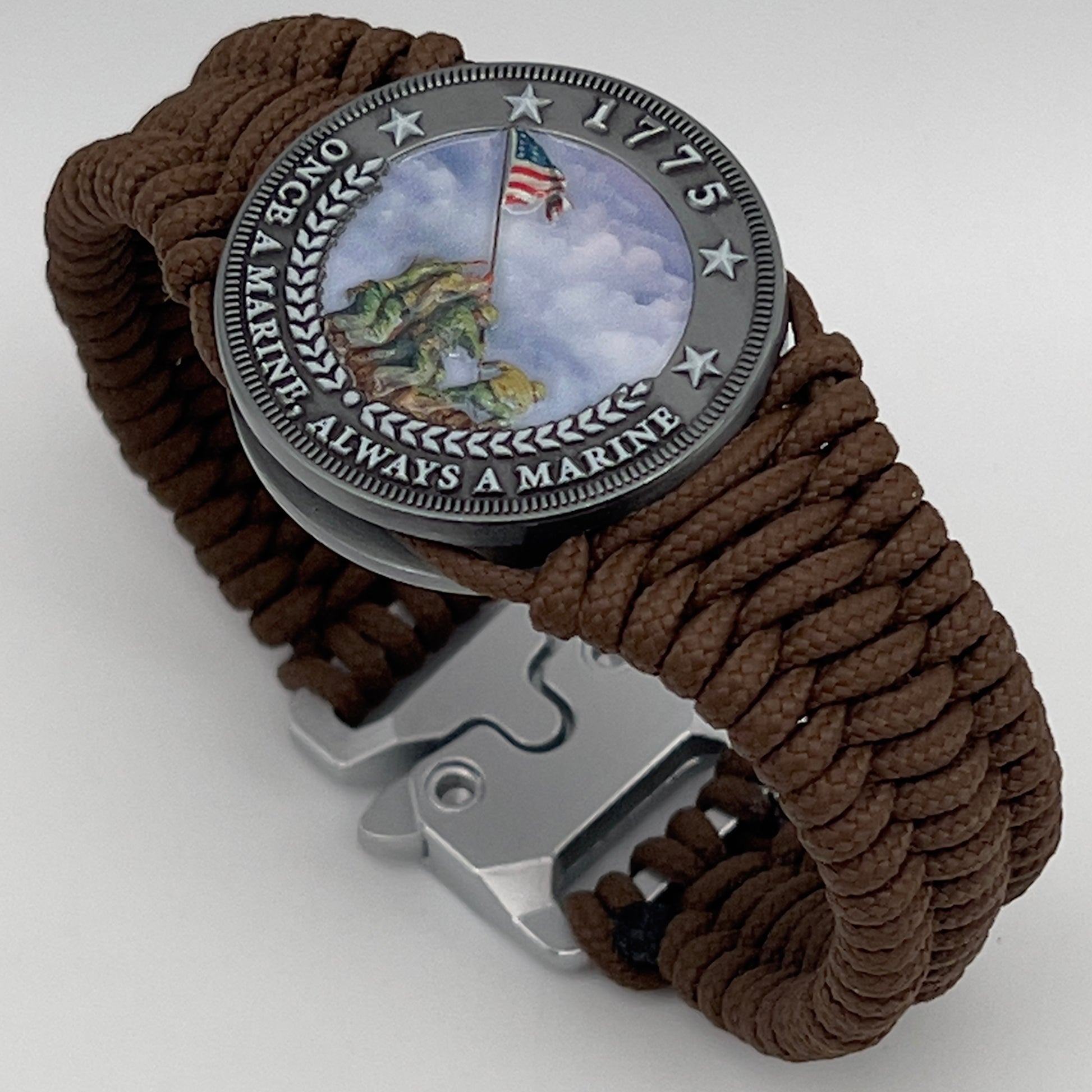 Thin, narrow, flexible and comfortable braided United States Marine Corps Iwo Jima bracelet featuring an antique silver plated UV painted Iwo Jima flag raising medallion, a silver Cobra style tactical buckle and woven with Coyote Brown type-1 paracord.
