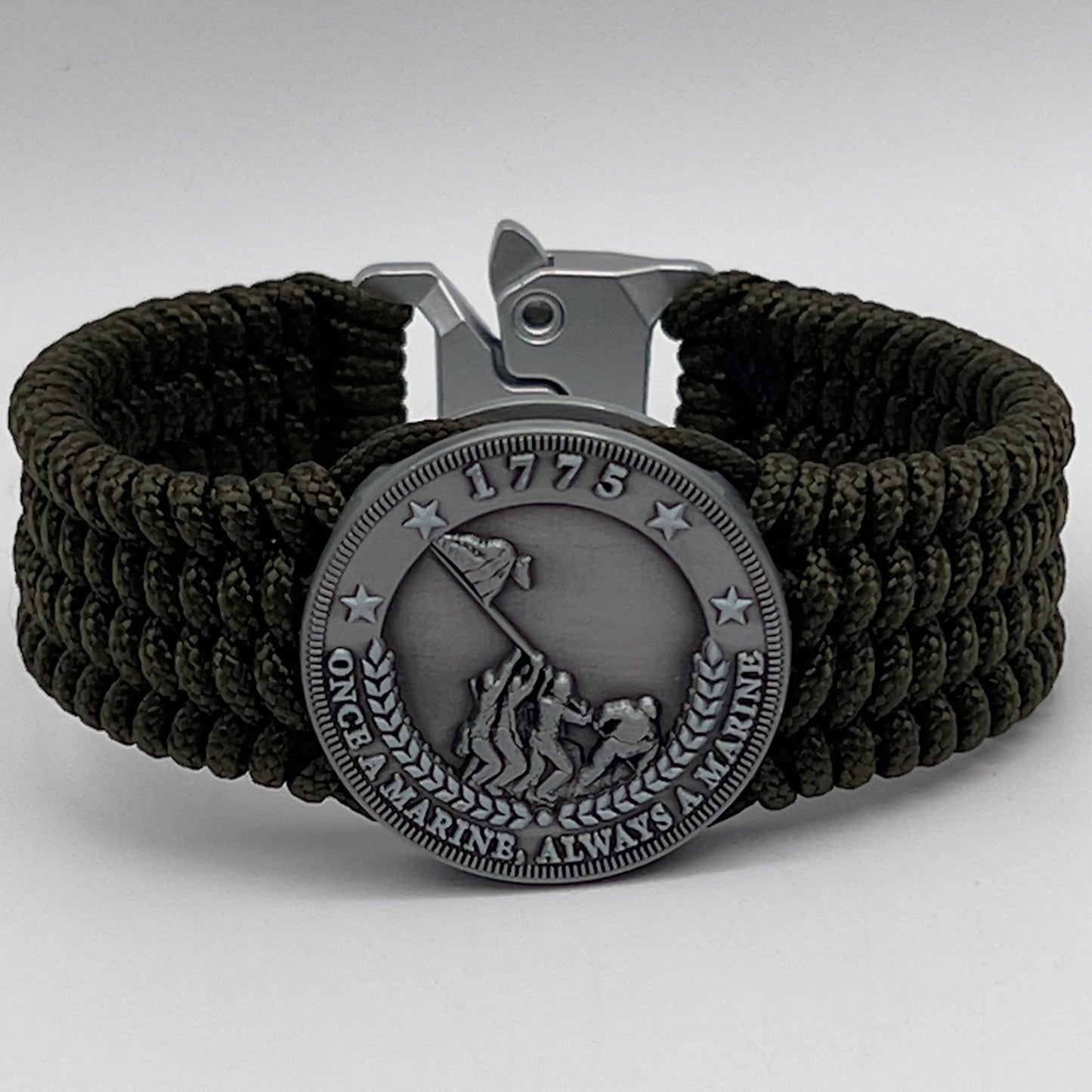 Thin, wide, flexible and comfortable braided United States Marine Corps Iwo Jima bracelet featuring an antique silver plated Iwo Jima flag raising medallion, a silver Cobra style tactical buckle and woven with olive drab type-1 paracord.