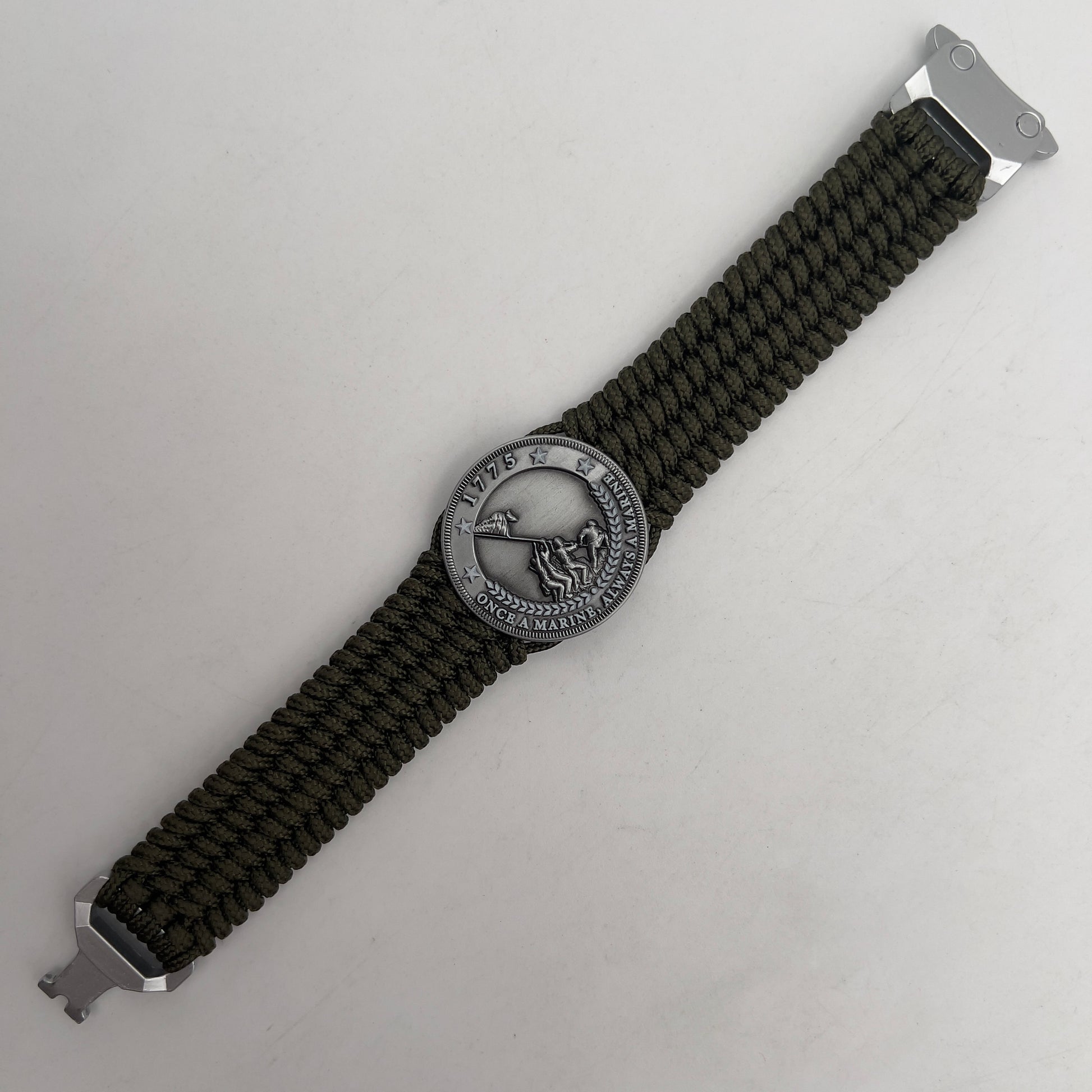 Thin, wide, flexible and comfortable braided United States Marine Corps Iwo Jima bracelet featuring an antique silver plated Iwo Jima flag raising medallion, a silver Cobra style tactical buckle and woven with olive drab type-1 paracord.