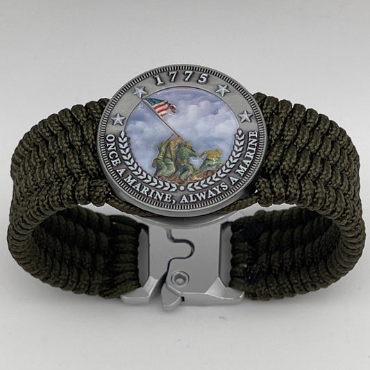 Thin, wide, flexible and comfortable braided United States Marine Corps Iwo Jima bracelet featuring an antique silver plated UV painted Iwo Jima flag raising medallion, a silver Cobra style tactical buckle and woven with olive drab Type-1 paracord.