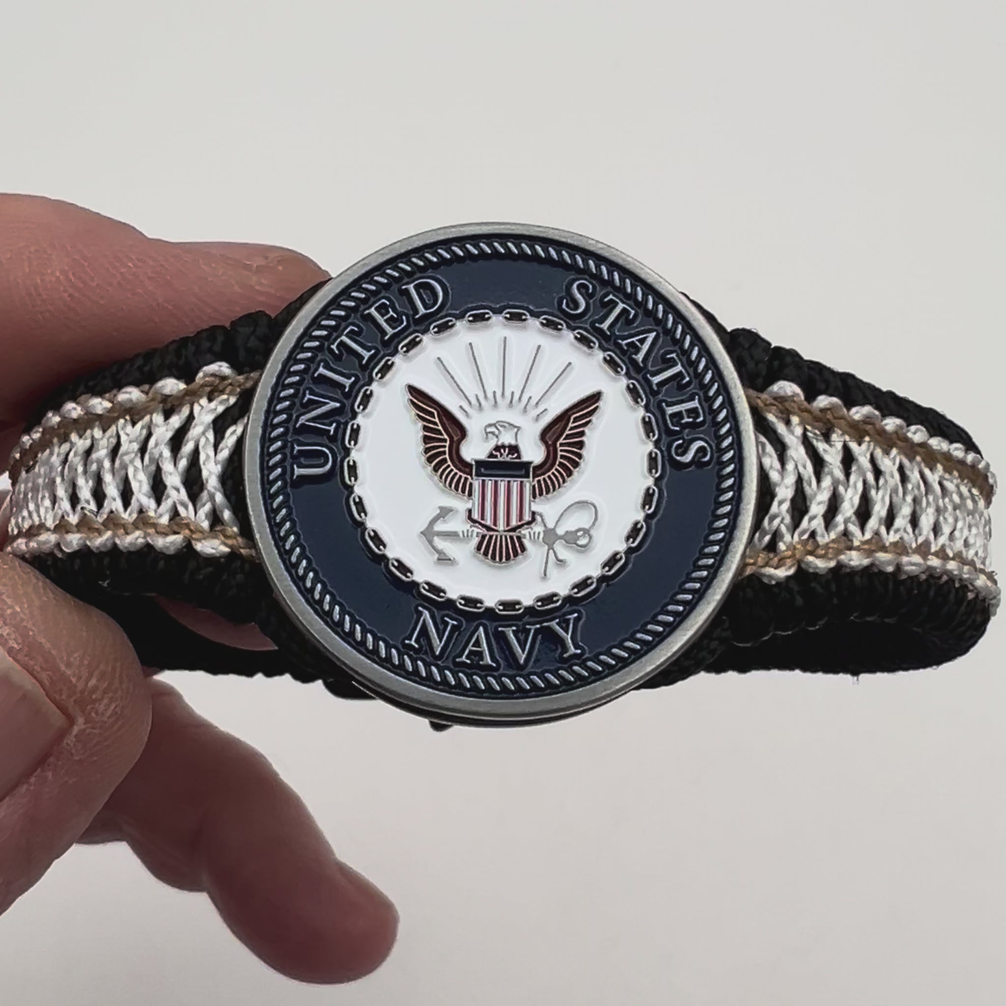 Thin, narrow, flexible and comfortable braided United States Marine Corps bracelet featuring an antique silver plated United States Navy medallion, a black Cobra style tactical buckle and woven with black Type-1 paracord and Gold adn White nano cord.