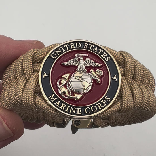 Thick and comfortable braided United States Marine Corps bracelet featuring a 24K gold and silver plated USMC officer Eagle Globe and Anchor medallion, a Cobra style tactical buckle and woven with gold 550 paracord.