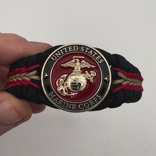 Thick, semi-rigid and comfortable braided United States Marine Corps bracelet featuring a 24K gold and silver plated USMC officer Eagle Globe and Anchor medallion, a black Cobra style tactical buckle and woven with black 550, Imperial red and gold micro paracord.