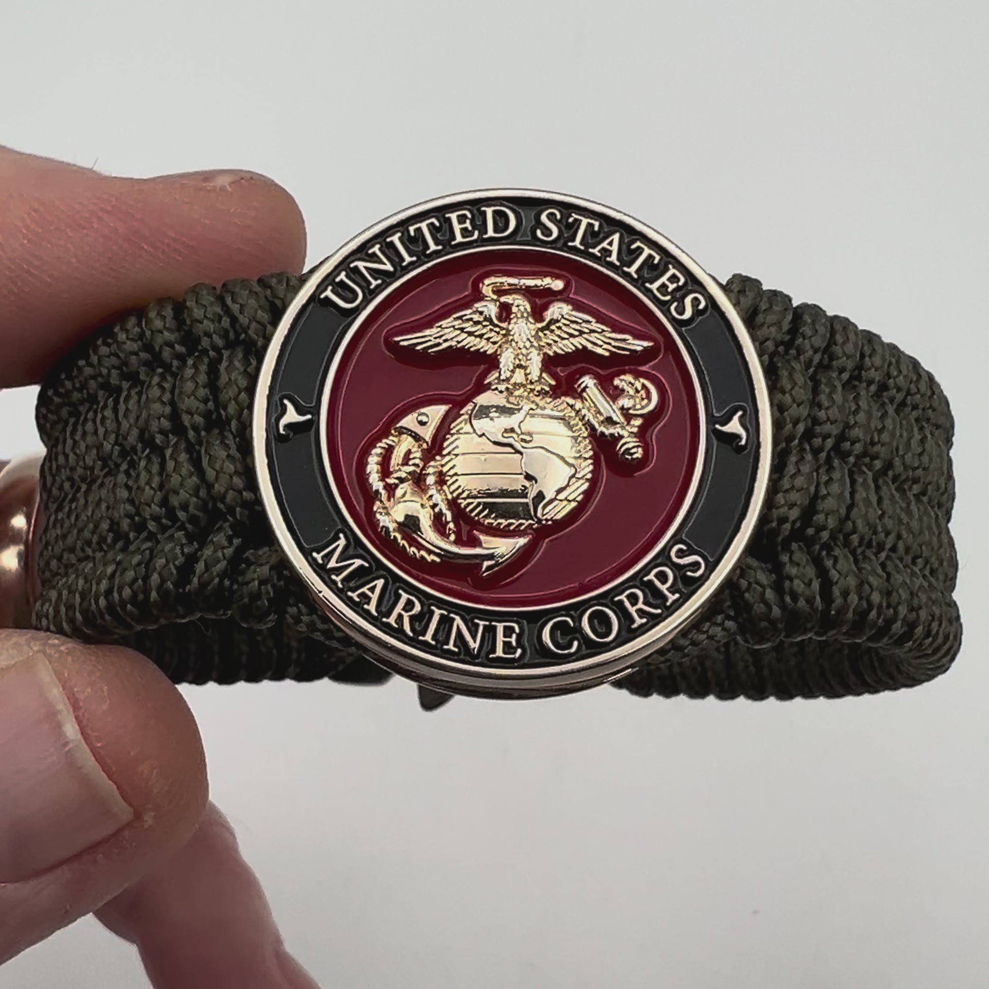Thin, medium width, flexible and comfortable braided United States Marine Corps bracelet featuring a 24K gold plated USMC officer Eagle Globe and Anchor medallion, a gold Cobra style tactical buckle and woven with Olive Drab Type-1 paracord.