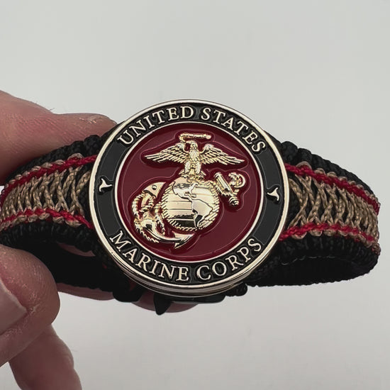 Thin, narrow, flexible and comfortable braided United States Marine Corps bracelet featuring a 24K gold plated USMC Eagle Globe and Anchor medallion, a black Cobra style tactical buckle and woven with black Type-1 paracord and Imperial Red and Gold nano cord.