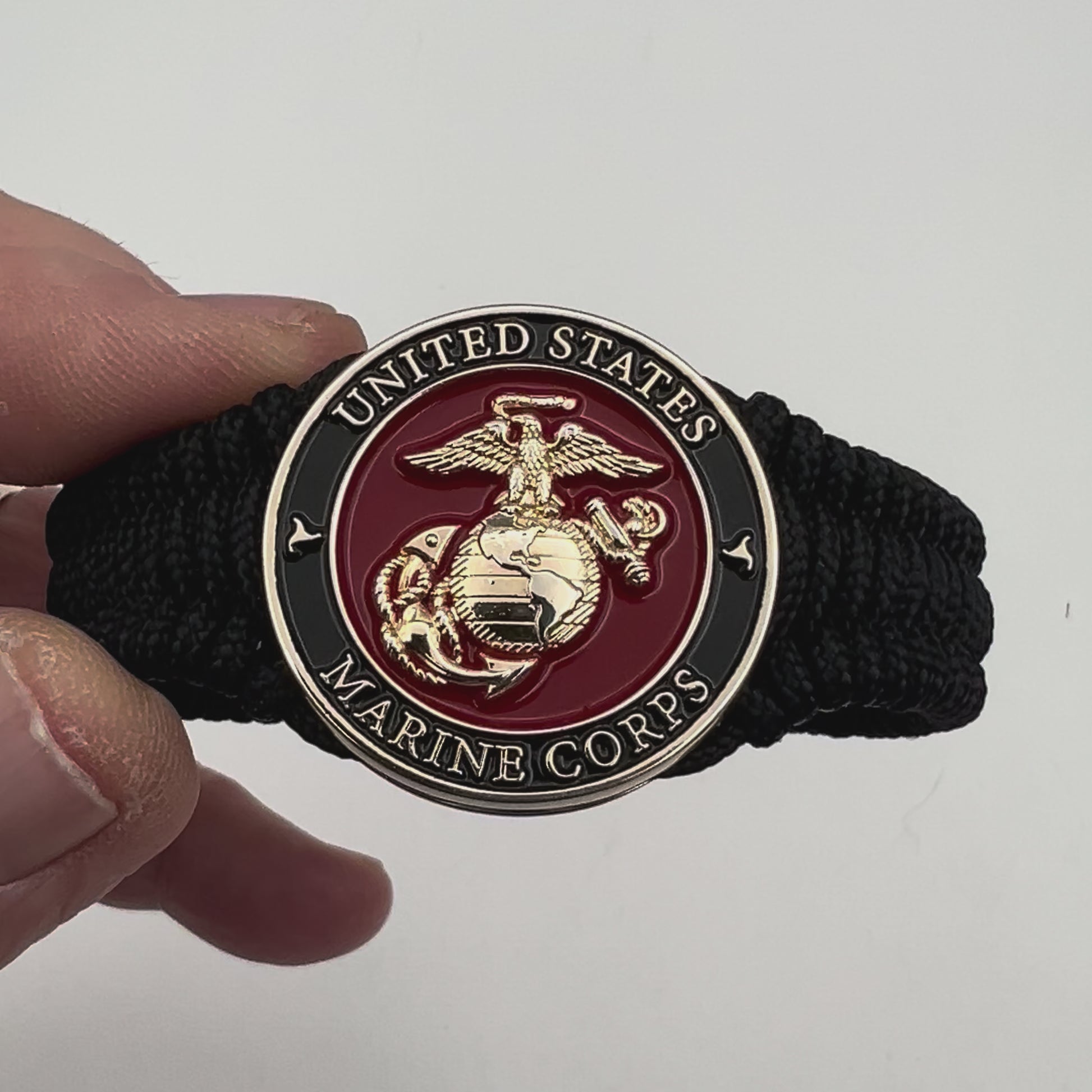 Thick, narrow, flexible and comfortable braided United States Marine Corps bracelet featuring a 24K gold plated USMC officer Eagle Globe and Anchor medallion, a black Cobra style tactical buckle and woven with black Type-1 paracord.