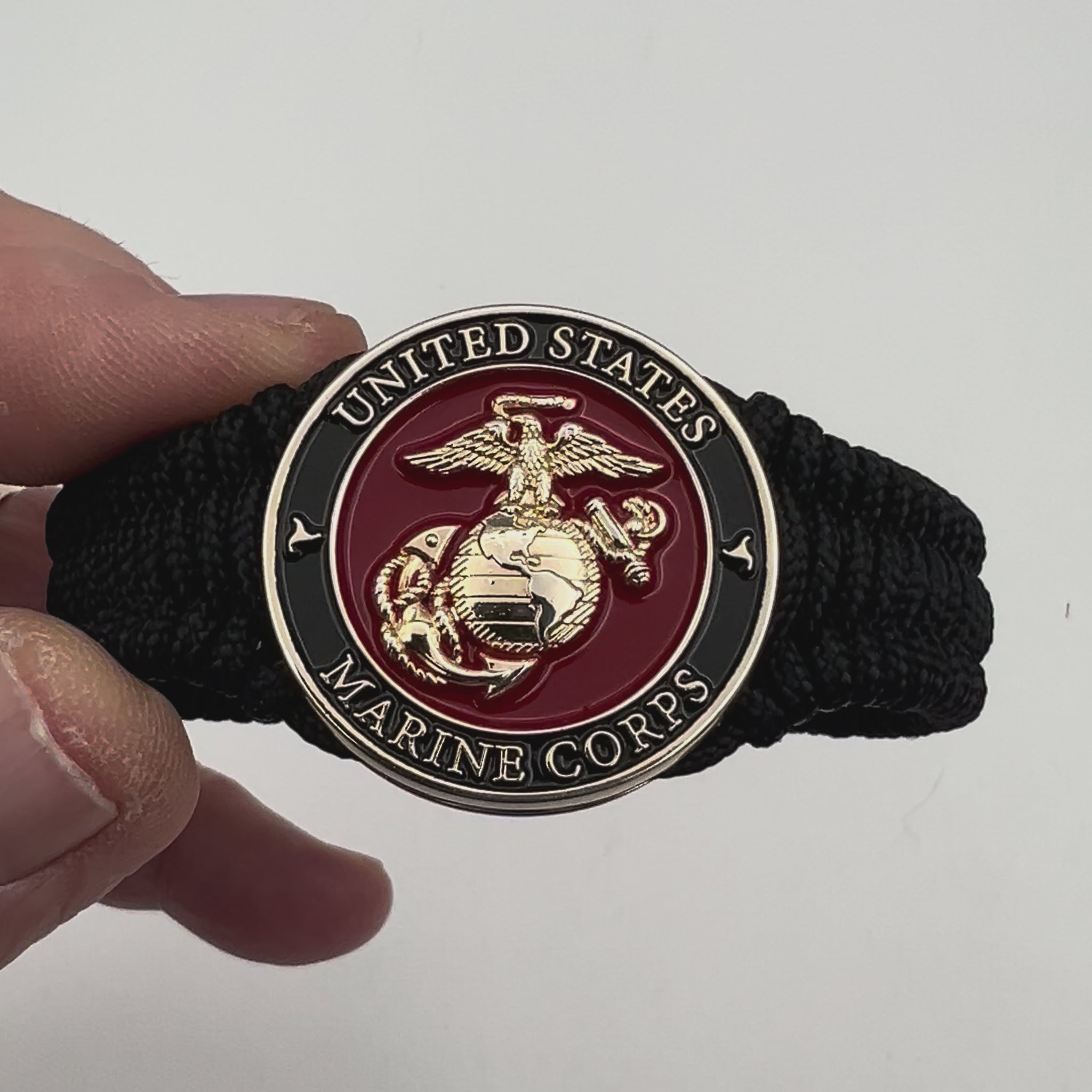 Thick, narrow, flexible and comfortable braided United States Marine Corps bracelet featuring a 24K gold plated USMC officer Eagle Globe and Anchor medallion, a black Cobra style tactical buckle and woven with black Type-1 paracord.