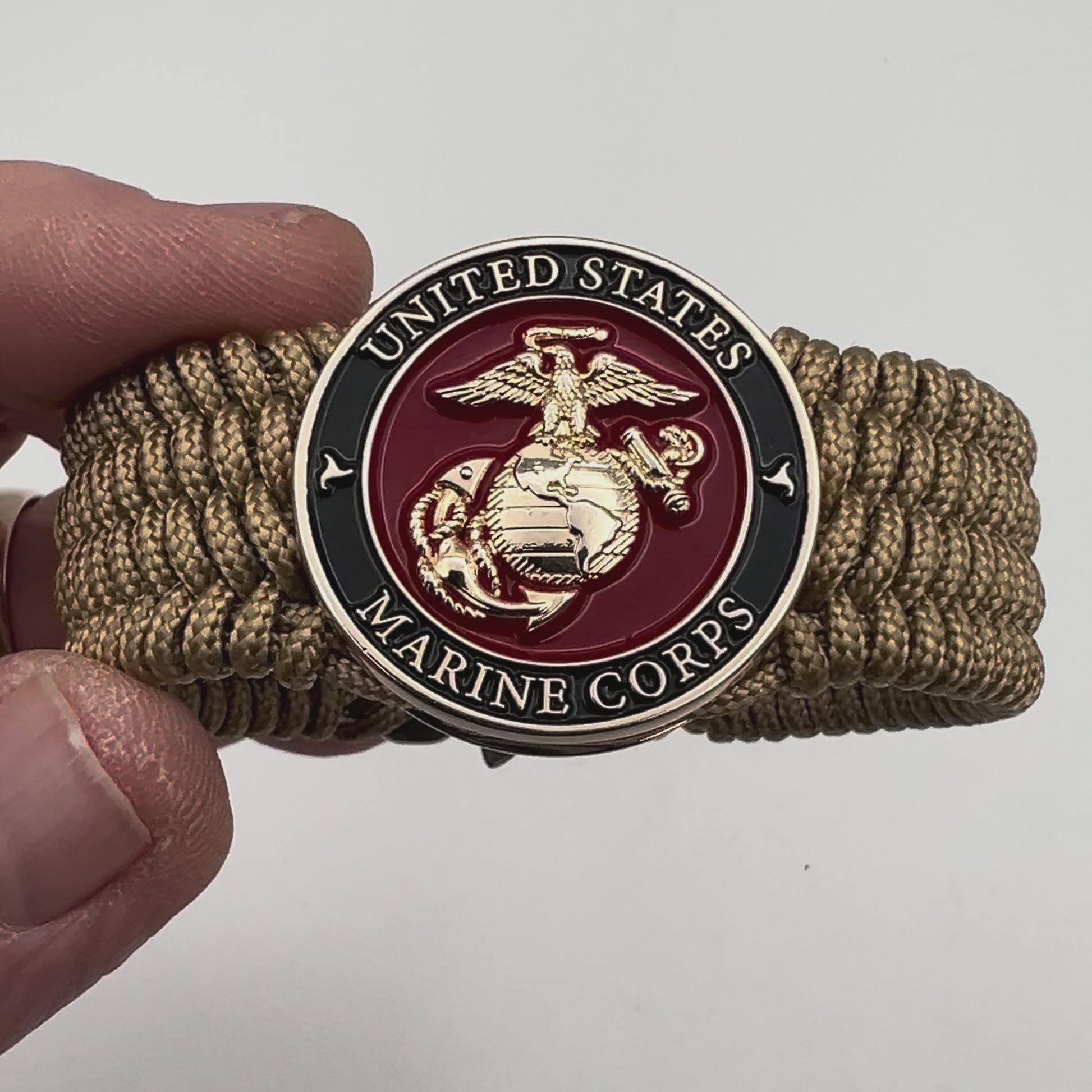 Thin, medium width, flexible and comfortable braided United States Marine Corps bracelet featuring a 24K gold plated USMC officer Eagle Globe and Anchor medallion, a gold Cobra style tactical buckle and woven with gold Type-1 paracord.