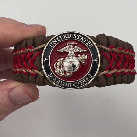 Thick and comfortable braided United States Marine Corps bracelet featuring a 24K gold and silver plated USMC officer Eagle Globe and Anchor medallion, a Cobra style tactical buckle and woven with Coyote Brown 550 paracord and Imperial Red and gold micro cord.