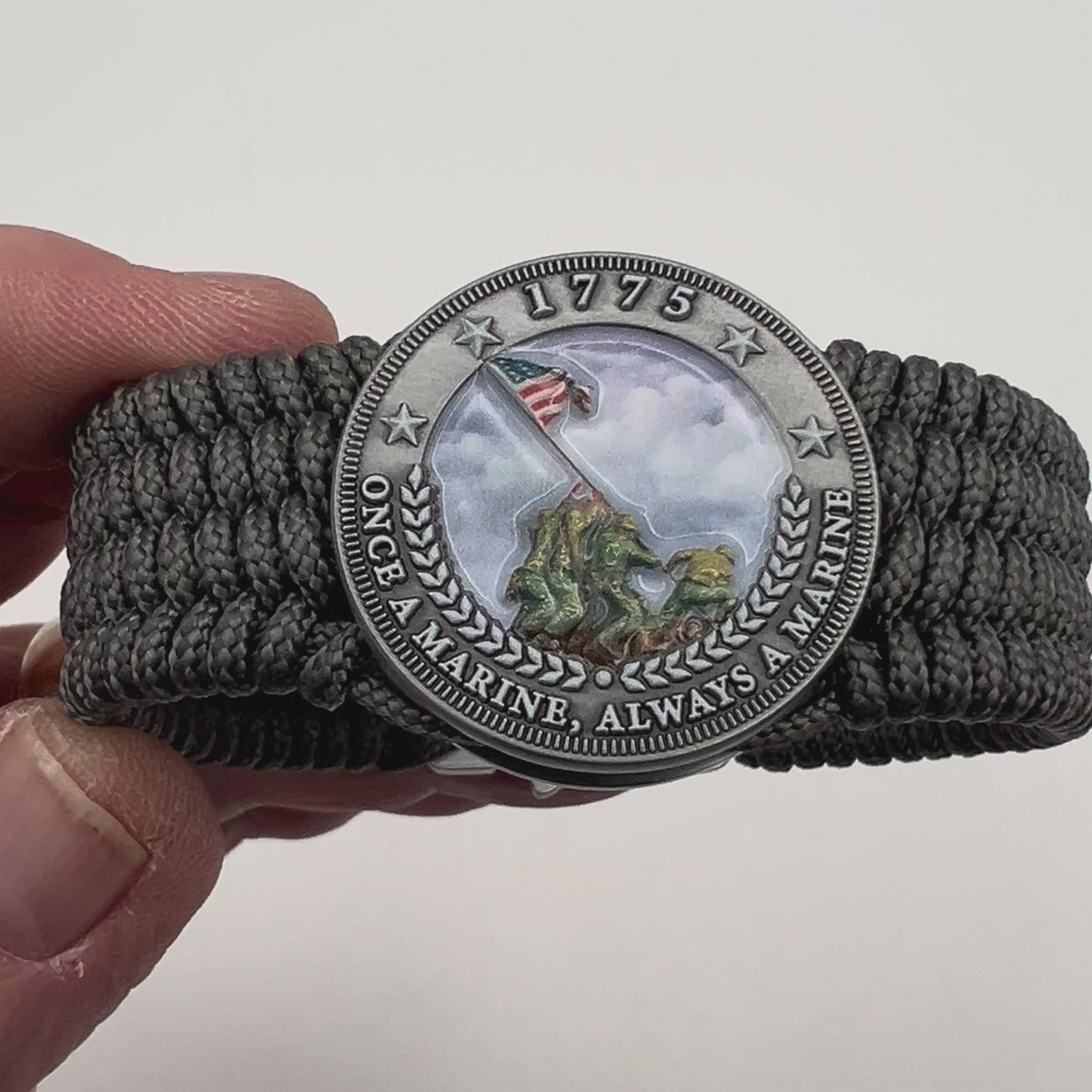 Thin, wide, flexible and comfortable braided United States Marine Corps Iwo Jima bracelet featuring an antique silver plated Iwo Jima flag raising medallion, a silver Cobra style tactical buckle and woven with gray Type-1 paracord.