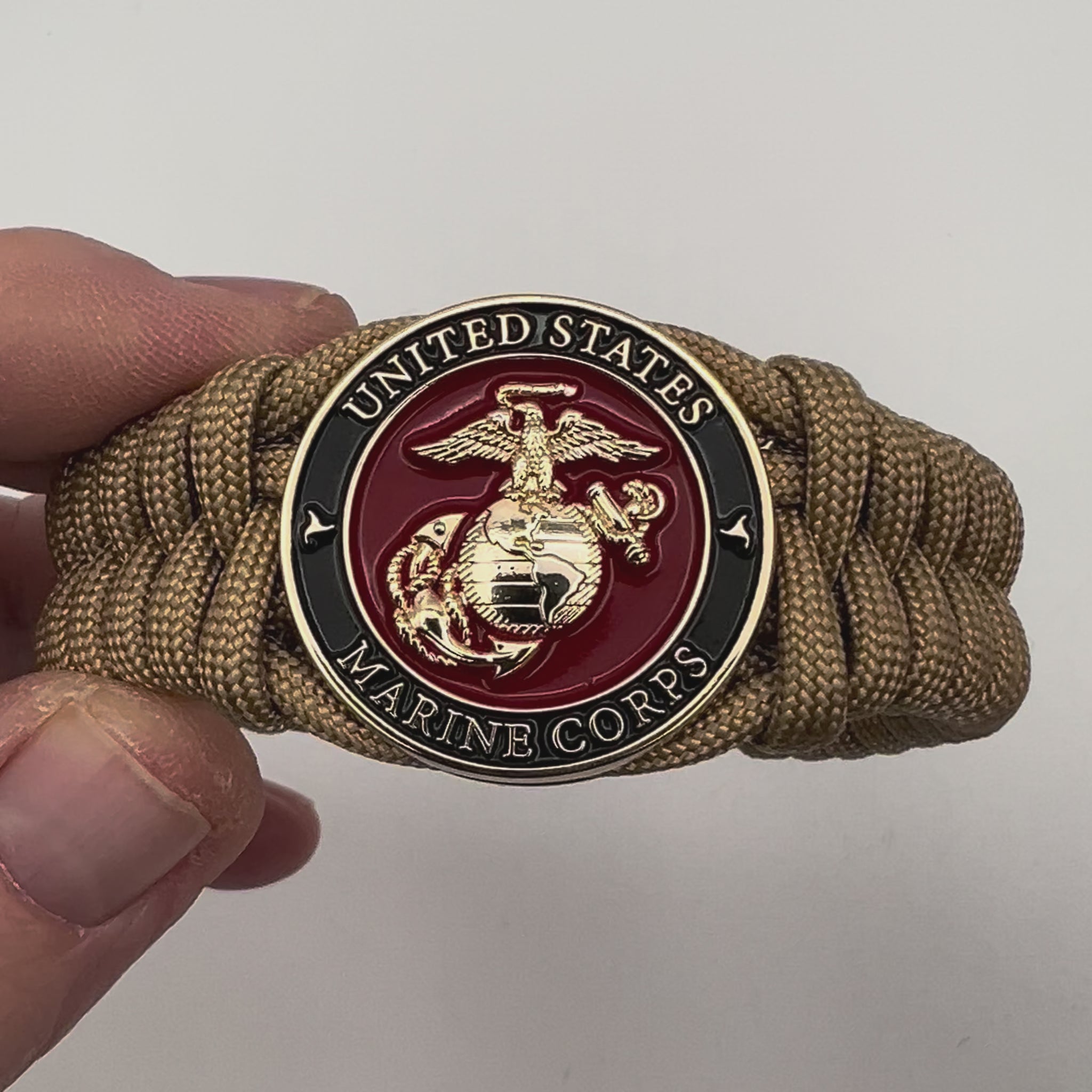 Thick, semi-rigid and comfortable braided United States Marine Corps bracelet featuring a 24K gold plated USMC officer Eagle Globe and Anchor medallion, a gold Cobra style tactical buckle and woven with gold 550 paracord.