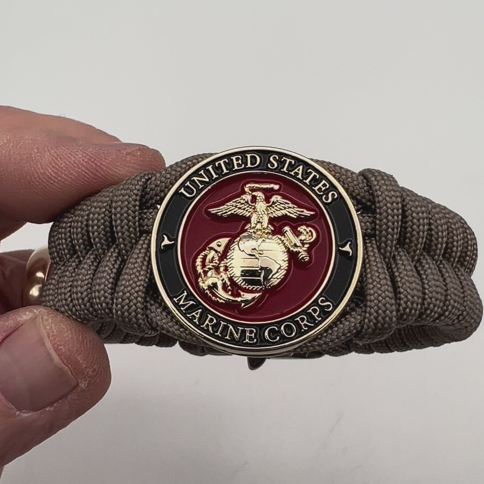 Thick, semi-rigid and comfortable braided United States Marine Corps bracelet featuring a 24K gold plated USMC Eagle Globe and Anchor medallion, a gold Cobra style tactical buckle and woven with tan 550 paracord.