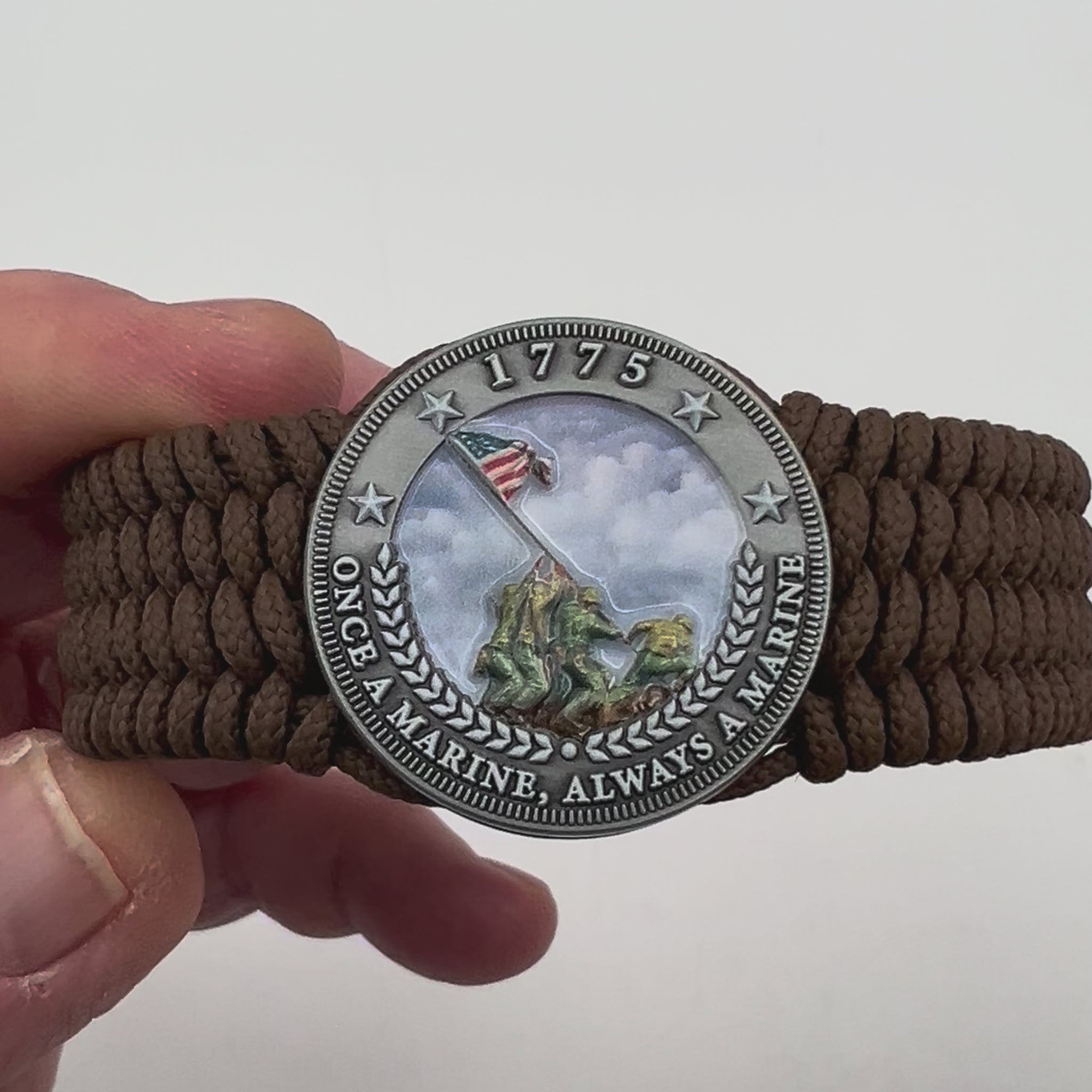 Thin, wide, flexible and comfortable braided United States Marine Corps Iwo Jima bracelet featuring an antique silver plated UV painted Iwo Jima flag raising medallion, a silver Cobra style tactical buckle and woven with Coyote Brown Type-1 paracord.