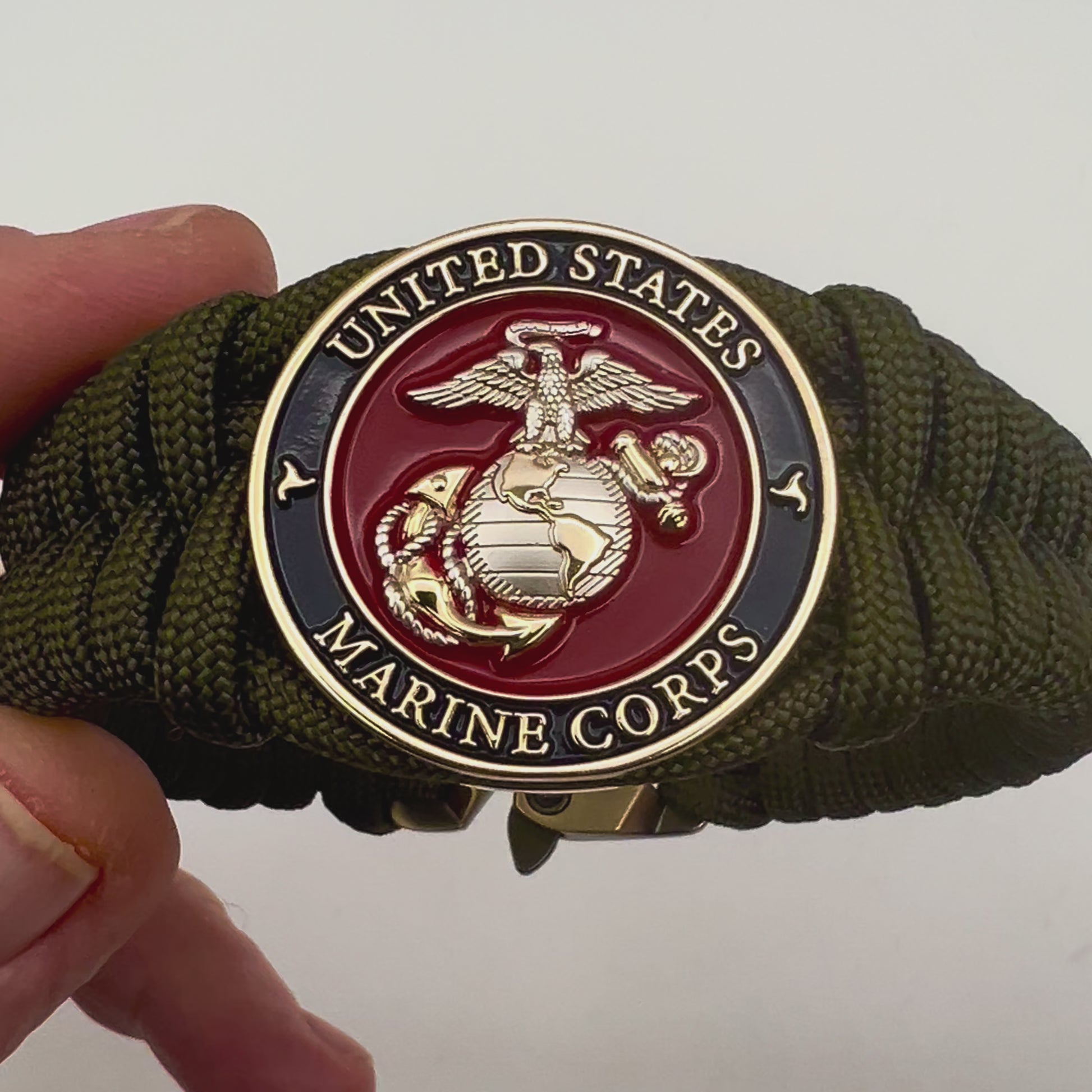 Thick, semi-rigid and comfortable braided United States Marine Corps bracelet featuring a 24K gold and silver plated USMC officer Eagle Globe and Anchor medallion, a gold Cobra style tactical buckle and woven with olive drab 550 paracord.