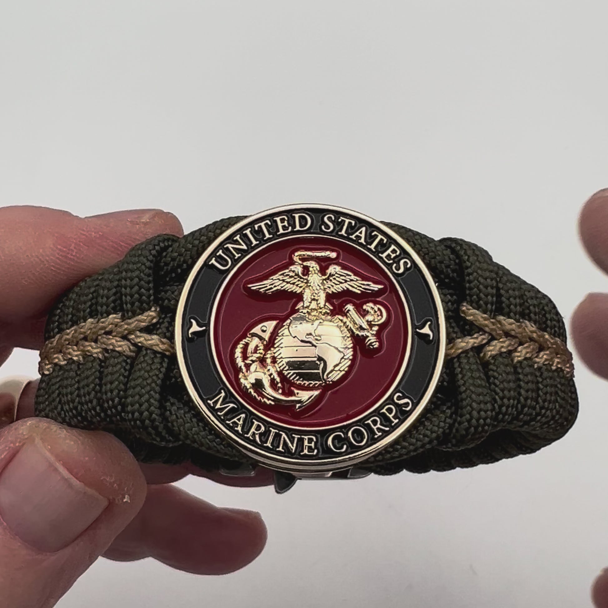 Thick, semi-rigid and comfortable braided United States Marine Corps bracelet featuring a 24K gold plated USMC officer Eagle Globe and Anchor medallion, a gold Cobra style tactical buckle and woven with olive drab 550 paracord and gold micro cord.