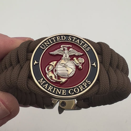 Thick and comfortable braided United States Marine Corps bracelet featuring a 24K gold and silver plated USMC officer Eagle Globe and Anchor medallion, a Cobra style tactical buckle and woven with Coyote brown 550 paracord.