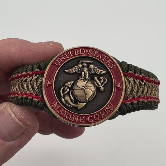 Thin, narrow, flexible and comfortable braided United States Marine Corps bracelet featuring a 24K antique gold plated USMC Eagle Globe and Anchor medallion, a gold Cobra style tactical buckle and woven with Olive Drab Type-1 paracord and Imperial Red and Gold nano cord.