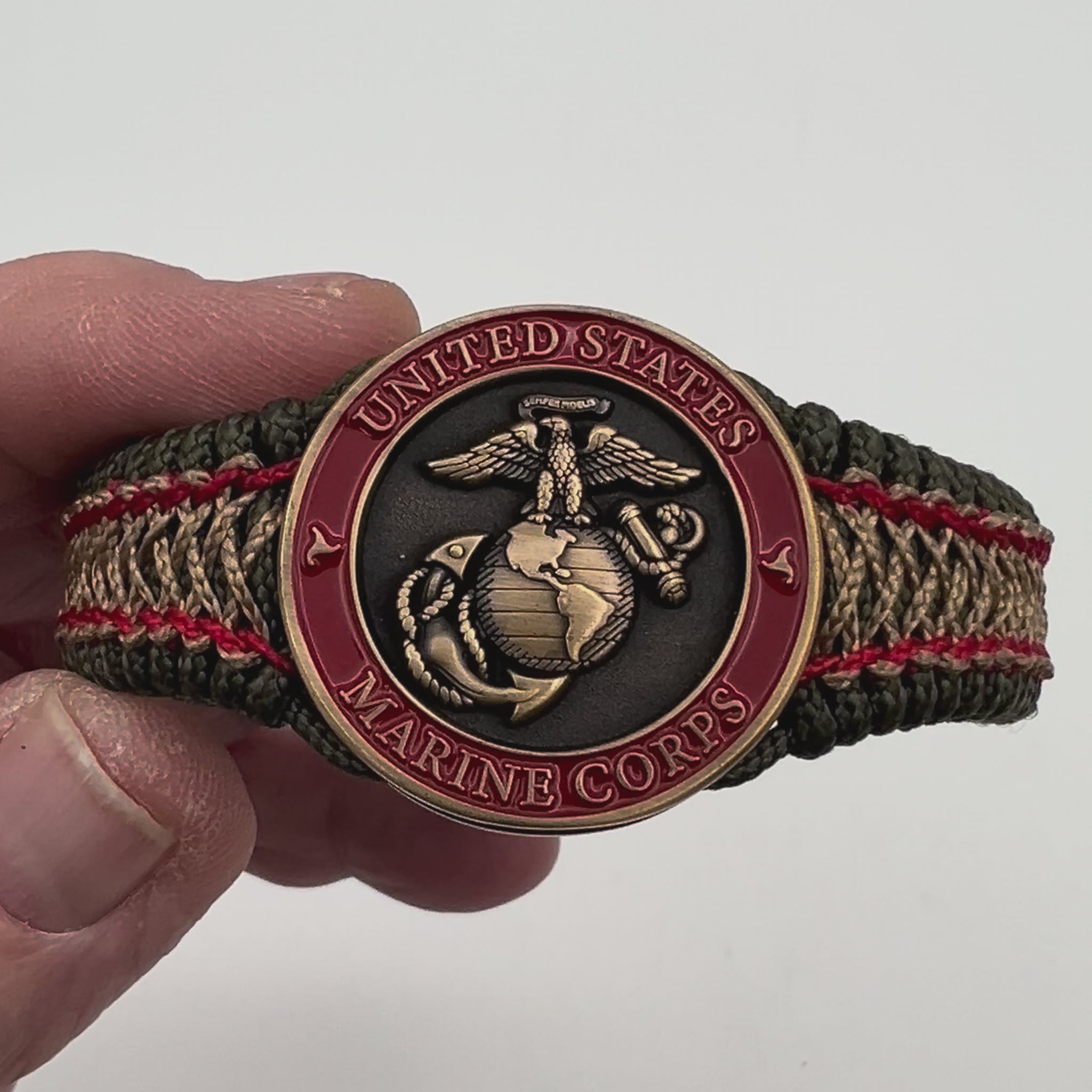 Thin, narrow, flexible and comfortable braided United States Marine Corps bracelet featuring a 24K antique gold plated USMC Eagle Globe and Anchor medallion, a gold Cobra style tactical buckle and woven with Olive Drab Type-1 paracord and Imperial Red and Gold nano cord.