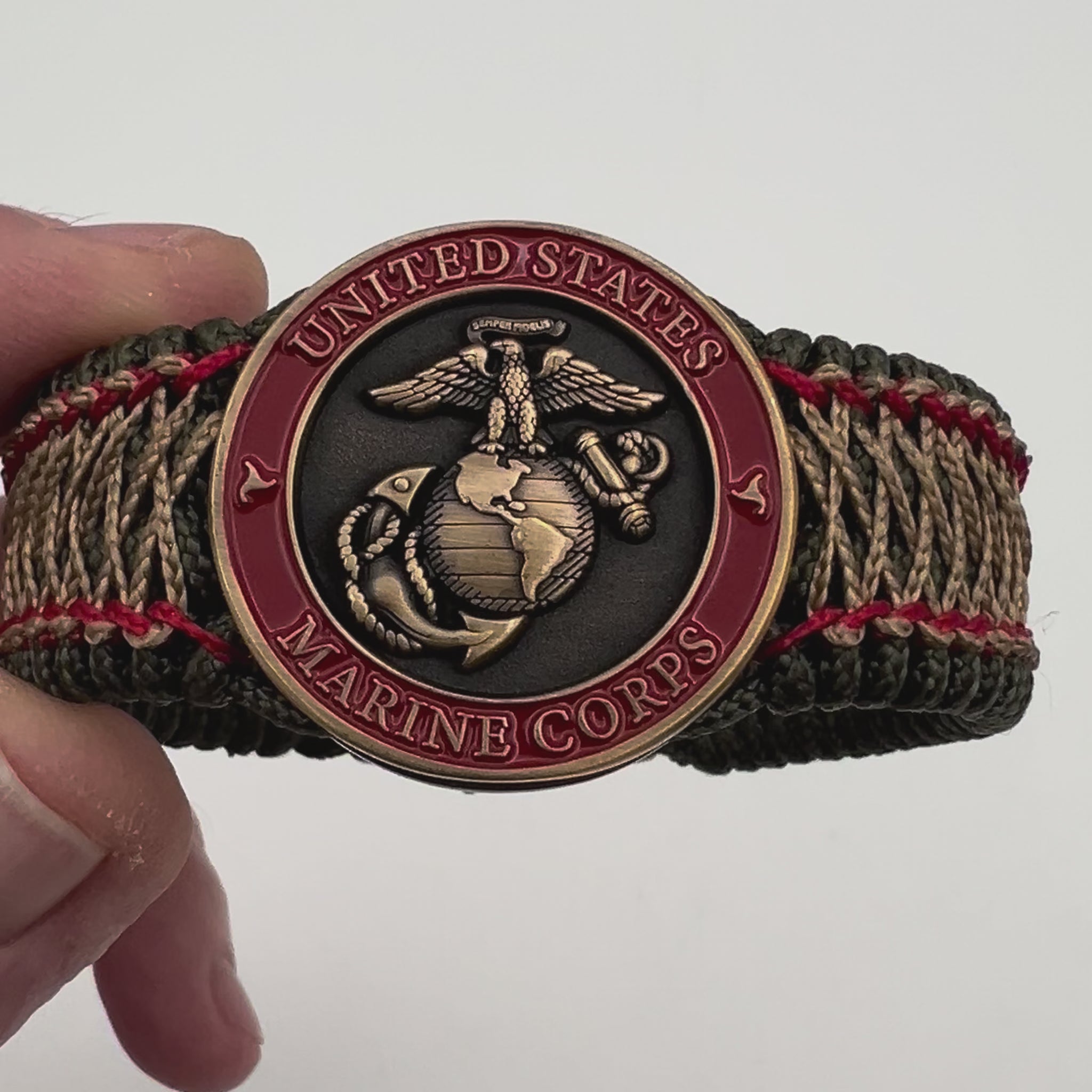 Thin, medium width, flexible and comfortable braided United States Marine Corps bracelet featuring a 24K antique gold plated USMC Eagle Globe and Anchor medallion, a gold Cobra style tactical buckle and woven with Olive Drab Type-1 paracord and Imperial Red and Gold nano cord.