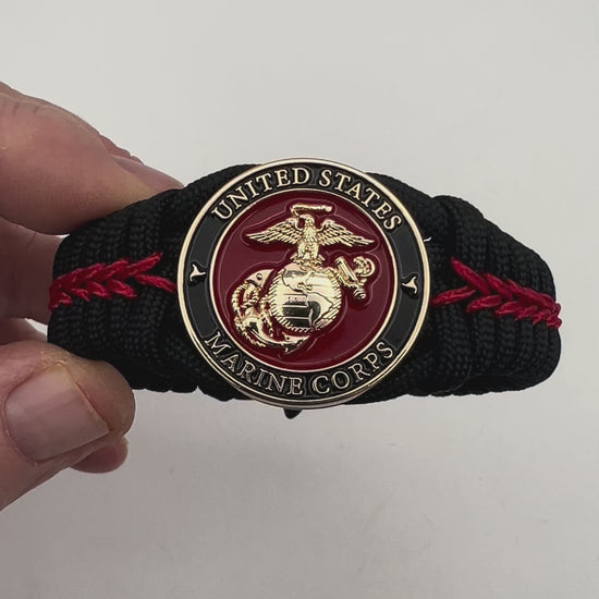 Thick, semi-rigid and comfortable braided United States Marine Corps bracelet featuring a 24K gold plated USMC officer Eagle Globe and Anchor medallion, a black Cobra style tactical buckle and woven with black 550 paracord and Imperial Red micro cord.
