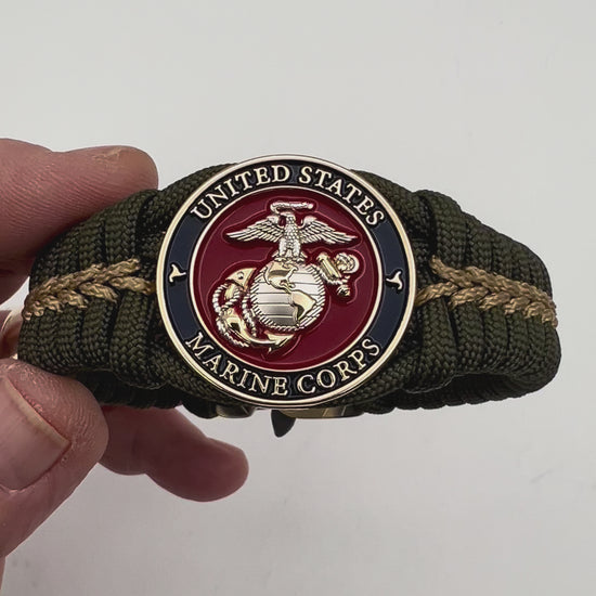 Thick, semi-rigid and comfortable braided United States Marine Corps bracelet featuring a 24K gold and silver plated USMC officer Eagle Globe and Anchor medallion, a gold Cobra style tactical buckle and woven with olive drab 550 and gold micro paracord.