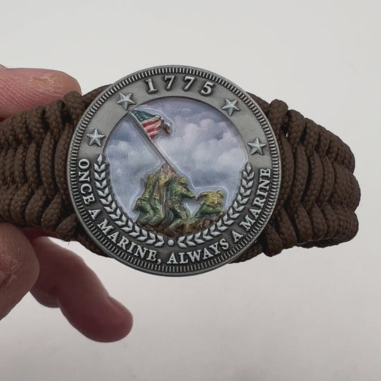 Thin, narrow, flexible and comfortable braided United States Marine Corps Iwo Jima bracelet featuring an antique silver plated UV painted Iwo Jima flag raising medallion, a silver Cobra style tactical buckle and woven with Coyote Brown type-1 paracord.