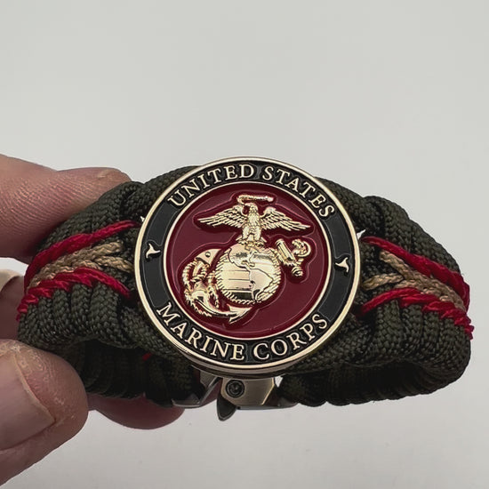 Thick, rigid and comfortable braided United States Marine Corps bracelet featuring a 24K gold plated USMC officer Eagle Globe and Anchor medallion, a gold Cobra style tactical buckle and woven with olive drab 550 paracord and Imperial Red and gold micro cord.