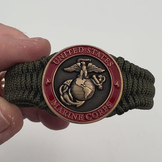 Thin, narrow, flexible and comfortable braided United States Marine Corps bracelet featuring a 24K antique gold plated USMC Eagle Globe and Anchor medallion, a gold Cobra style tactical buckle and woven with Olive Drab Type-1 paracord.