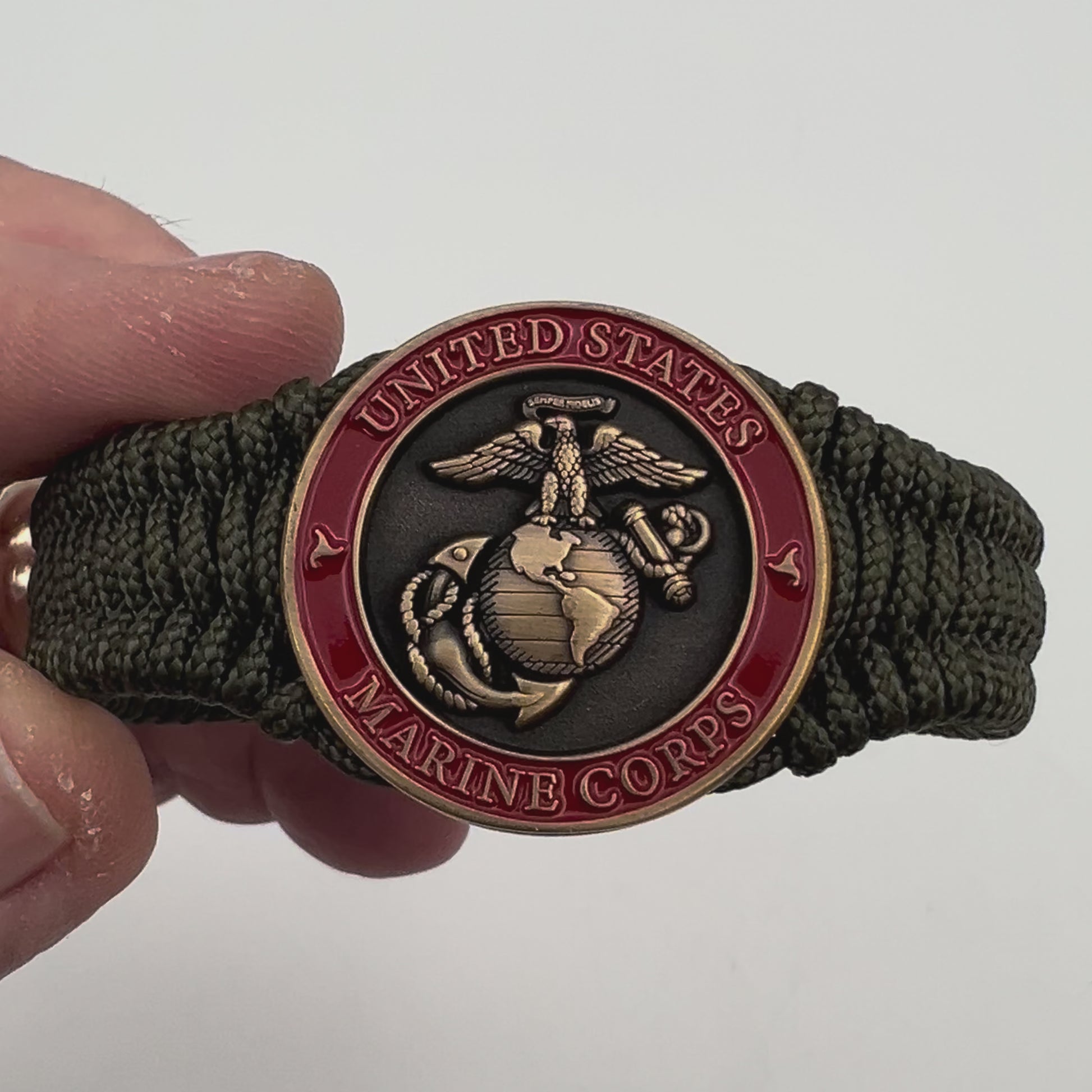 Thin, narrow, flexible and comfortable braided United States Marine Corps bracelet featuring a 24K antique gold plated USMC Eagle Globe and Anchor medallion, a gold Cobra style tactical buckle and woven with Olive Drab Type-1 paracord.