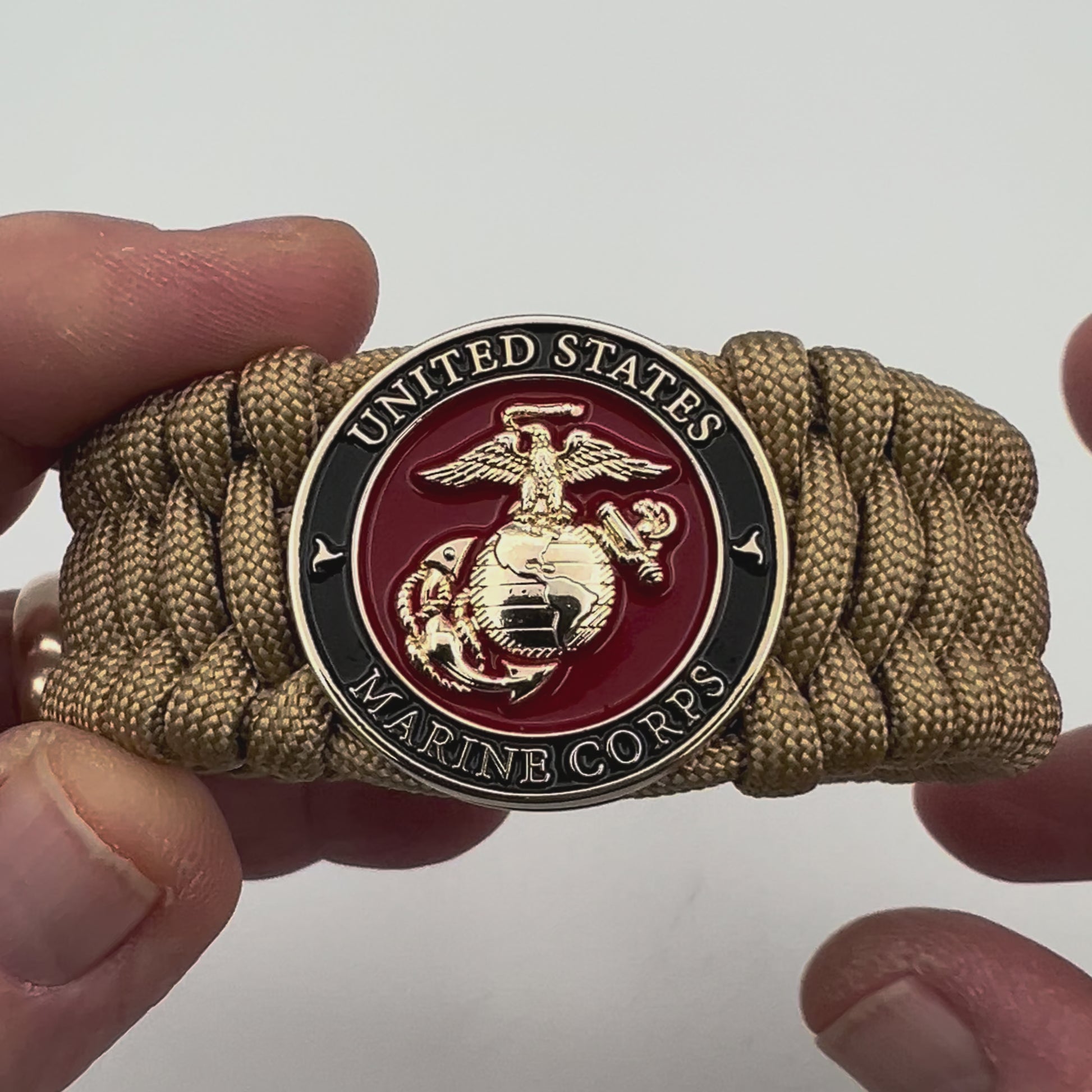 Thick, wide, rigid and comfortable braided United States Marine Corps bracelet featuring a 24K gold plated USMC Eagle Globe and Anchor medallion, a gold Cobra style tactical buckle and woven with gold 550 paracord.