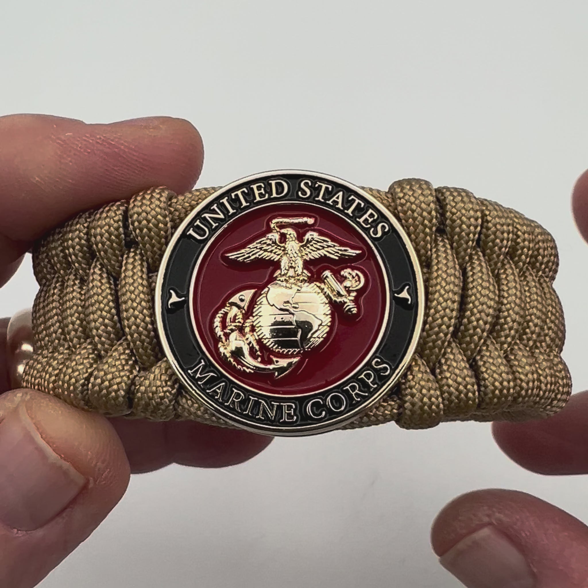 Thick, wide, rigid and comfortable braided United States Marine Corps bracelet featuring a 24K gold plated USMC Eagle Globe and Anchor medallion, a gold Cobra style tactical buckle and woven with gold 550 paracord.