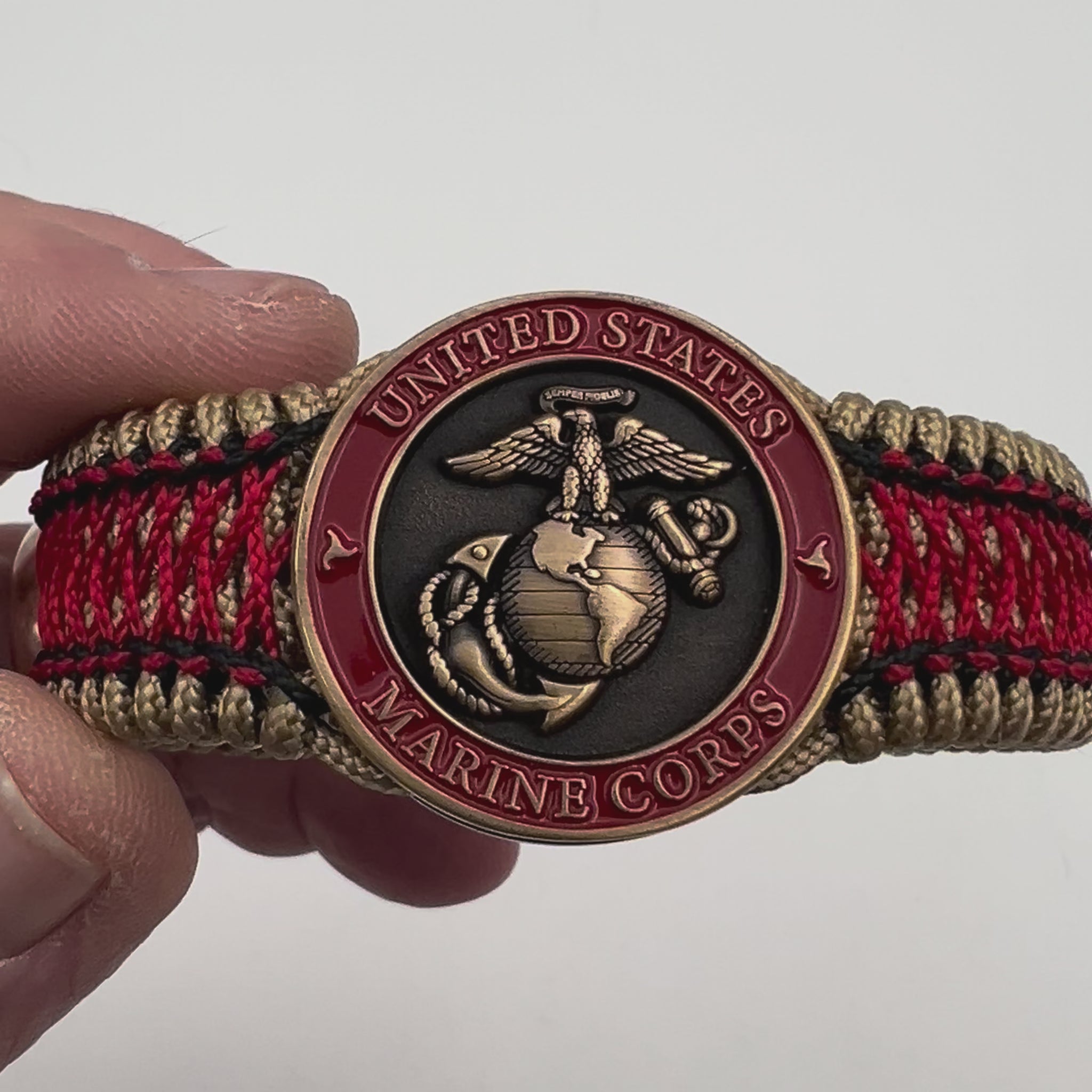 Thin, medium width, flexible and comfortable braided United States Marine Corps bracelet featuring a 24K antique gold plated USMC Eagle Globe and Anchor medallion, a gold Cobra style tactical buckle and woven with gold Type-1 paracord and Imperial Red and Black nano cord.