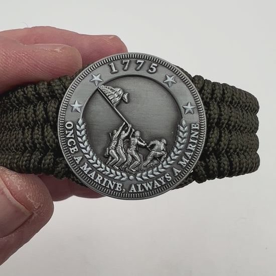 Thin, wide, flexible and comfortable braided United States Marine Corps Iwo Jima bracelet featuring an antique silver plated Iwo Jima flag raising medallion, a silver Cobra style tactical buckle and woven with olive drab type-1 paracord.