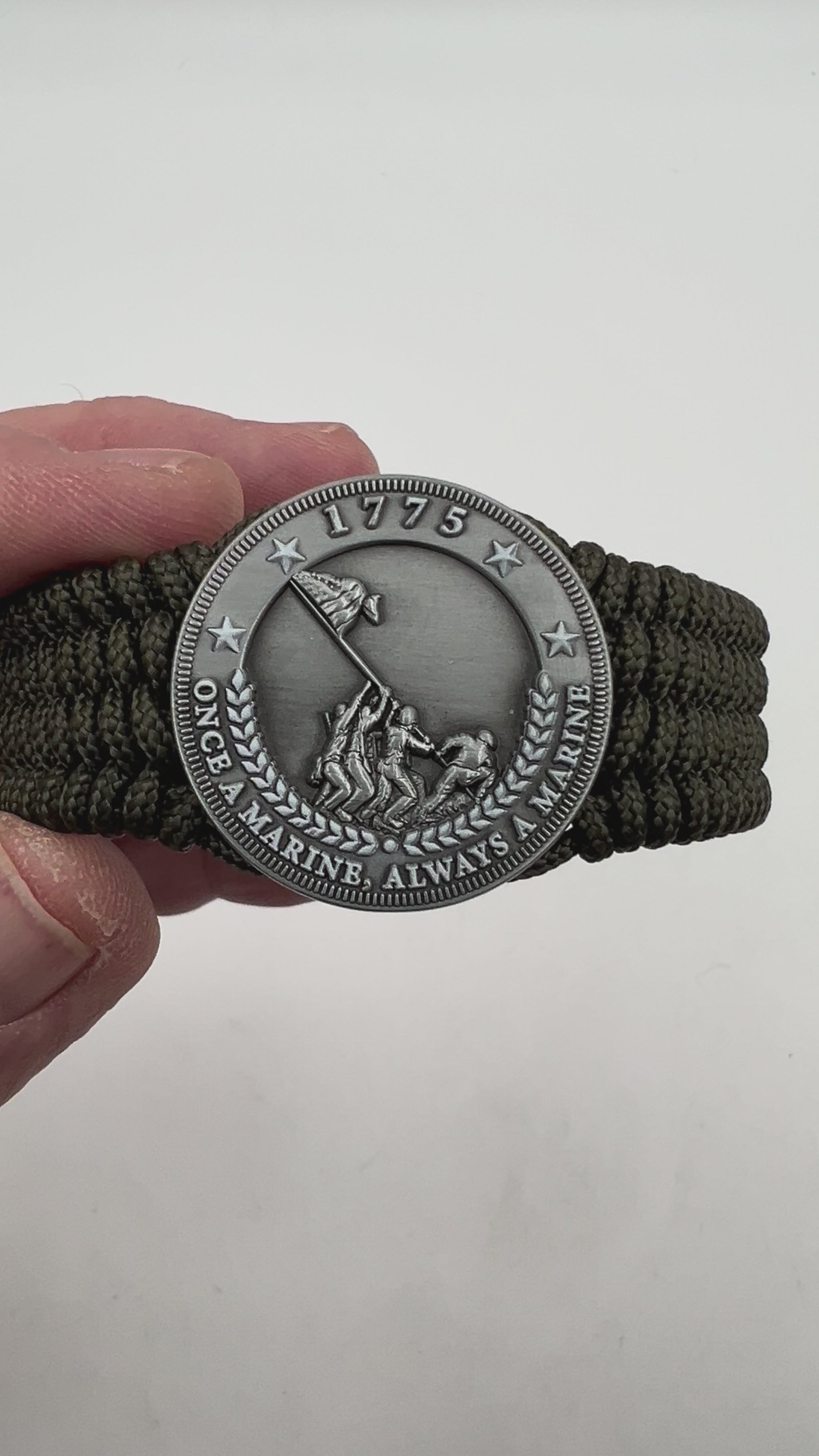 Thin, wide, flexible and comfortable braided United States Marine Corps Iwo Jima bracelet featuring an antique silver plated Iwo Jima flag raising medallion, a silver Cobra style tactical buckle and woven with olive drab type-1 paracord.