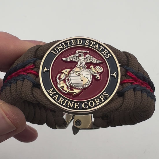 Thick, semi-rigid and comfortable braided United States Marine Corps bracelet featuring a 24K gold and silver plated USMC officer Eagle Globe and Anchor medallion, a Cobra style tactical buckle and woven with Coyote brown 550, Navy blue and Imperial red micro paracord.