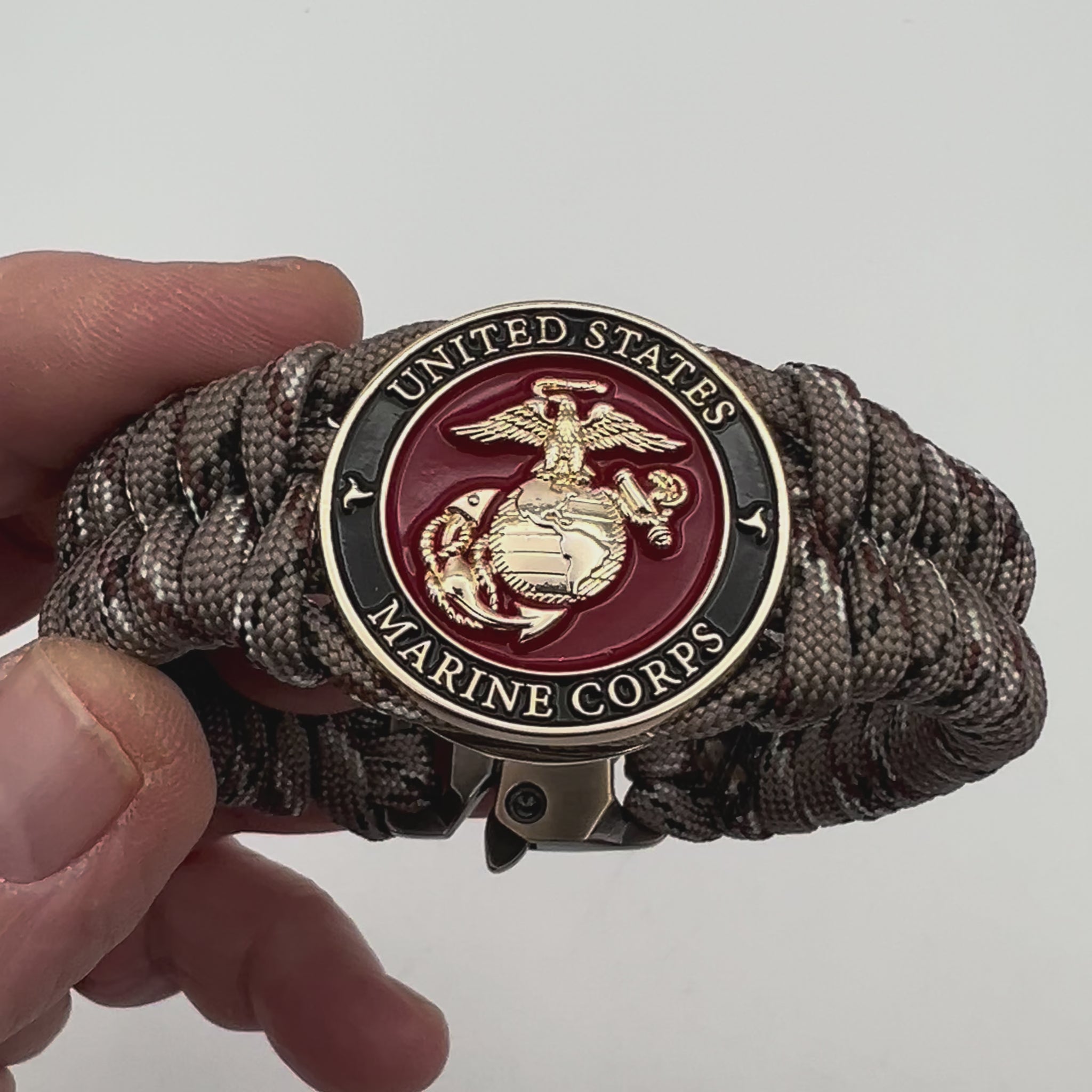 Thick, semi-rigid and comfortable braided United States Marine Corps bracelet featuring a 24K gold plated USMC Eagle Globe and Anchor medallion, a gold Cobra style tactical buckle and woven with Desert Camo 550 paracord.
