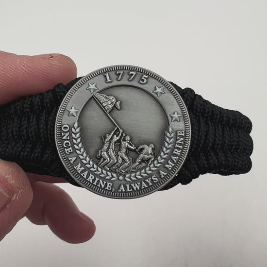 Thin, narrow and comfortable braided United States Marine Corps Iwo Jima bracelet featuring an antique silver plated Iwo Jima flag raising medallion, a black Cobra style tactical buckle and woven with black type-1 paracord.