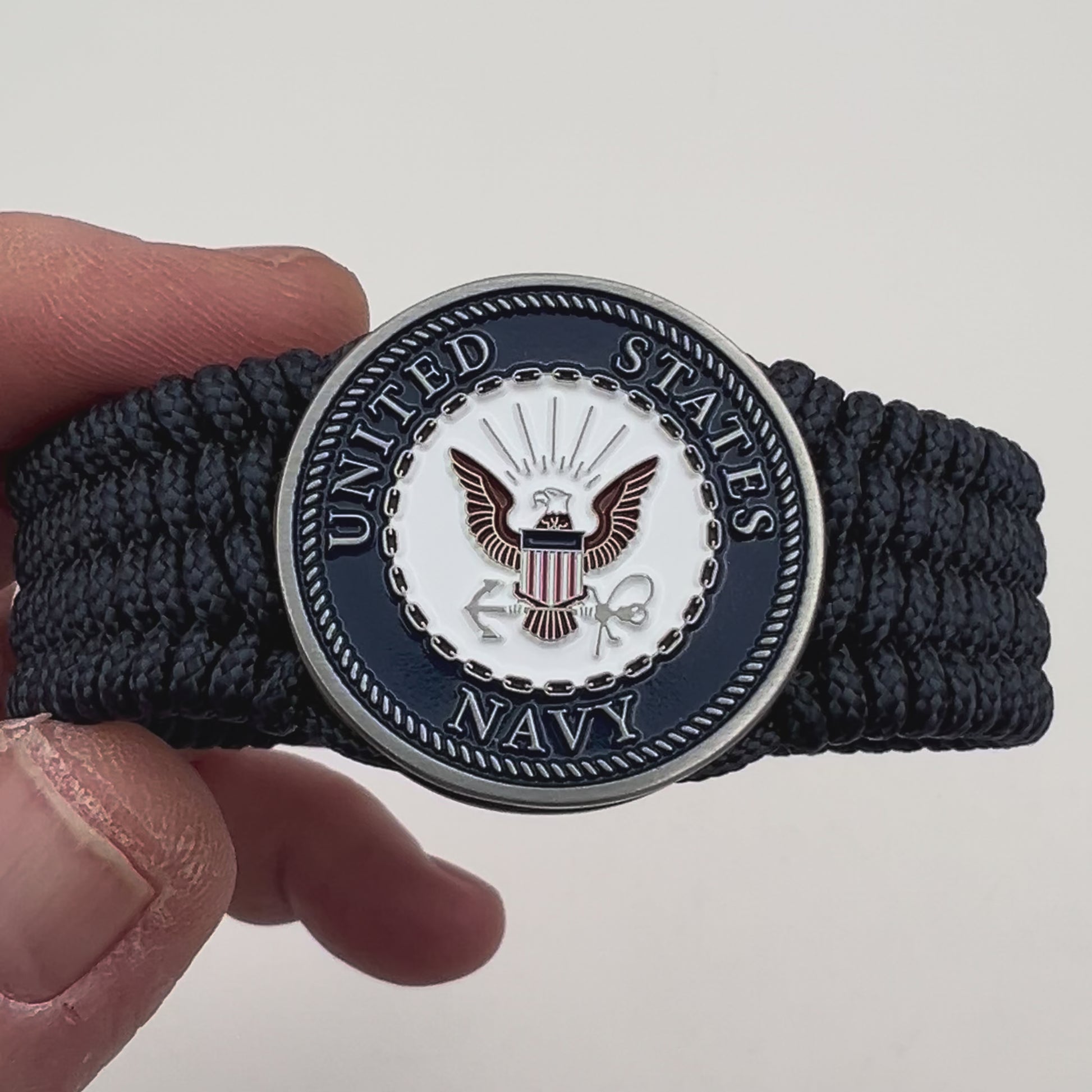 Thin, wide, flexible and comfortable braided United States Navy bracelet featuring an antique silver plated Navy medallion, a black Cobra style tactical buckle and woven with Navy Blue Type-1 paracord.